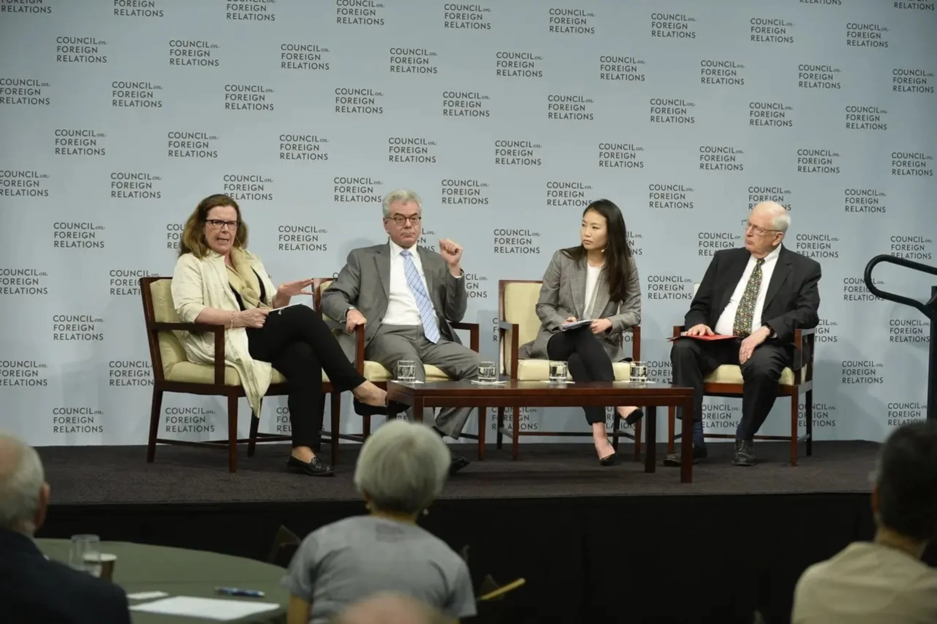 Photo of a panel of four people sitting on a raised stage.