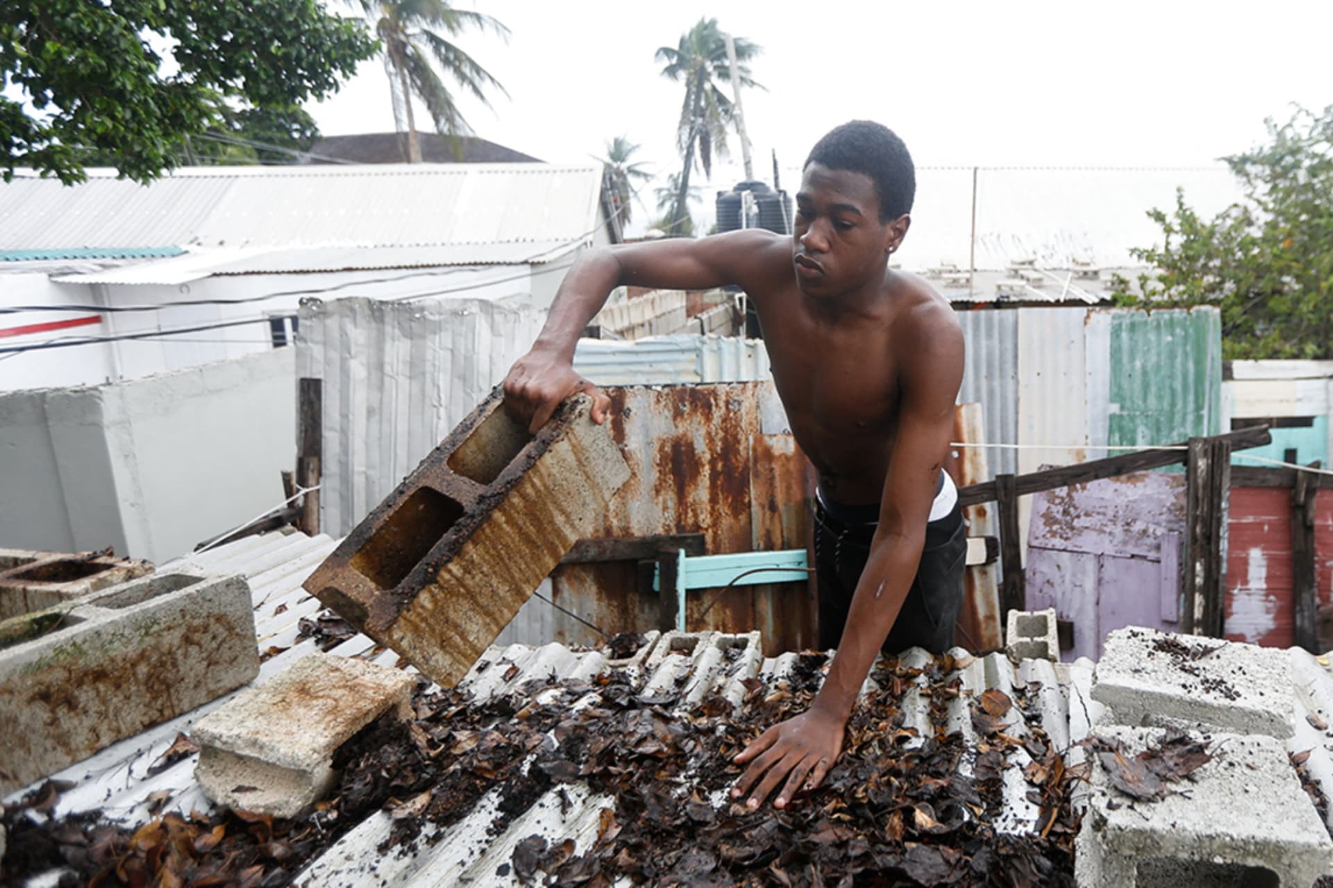 <p>A man places concrete blocks on a roof, in preparation for the arrival of Hurricane Melissa, in Port Royal, Jamaica, October 26, 2025.</p>