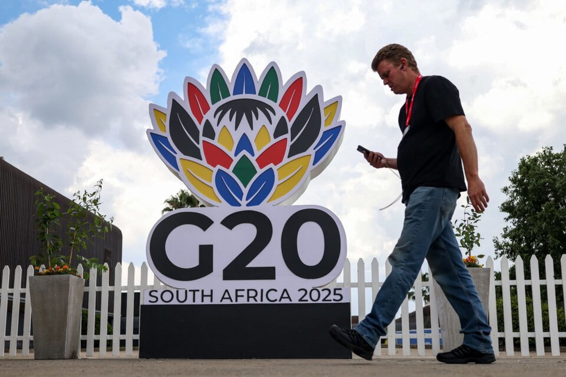 <p>A man walks past a G20 South Africa 2025 sign inside the secured area of the G20 Summit venue at the Nasrec Expo centre, ahead of the summit scheduled for November 22–23 in Johannesburg, South Africa. November 21, 2025. </p>
