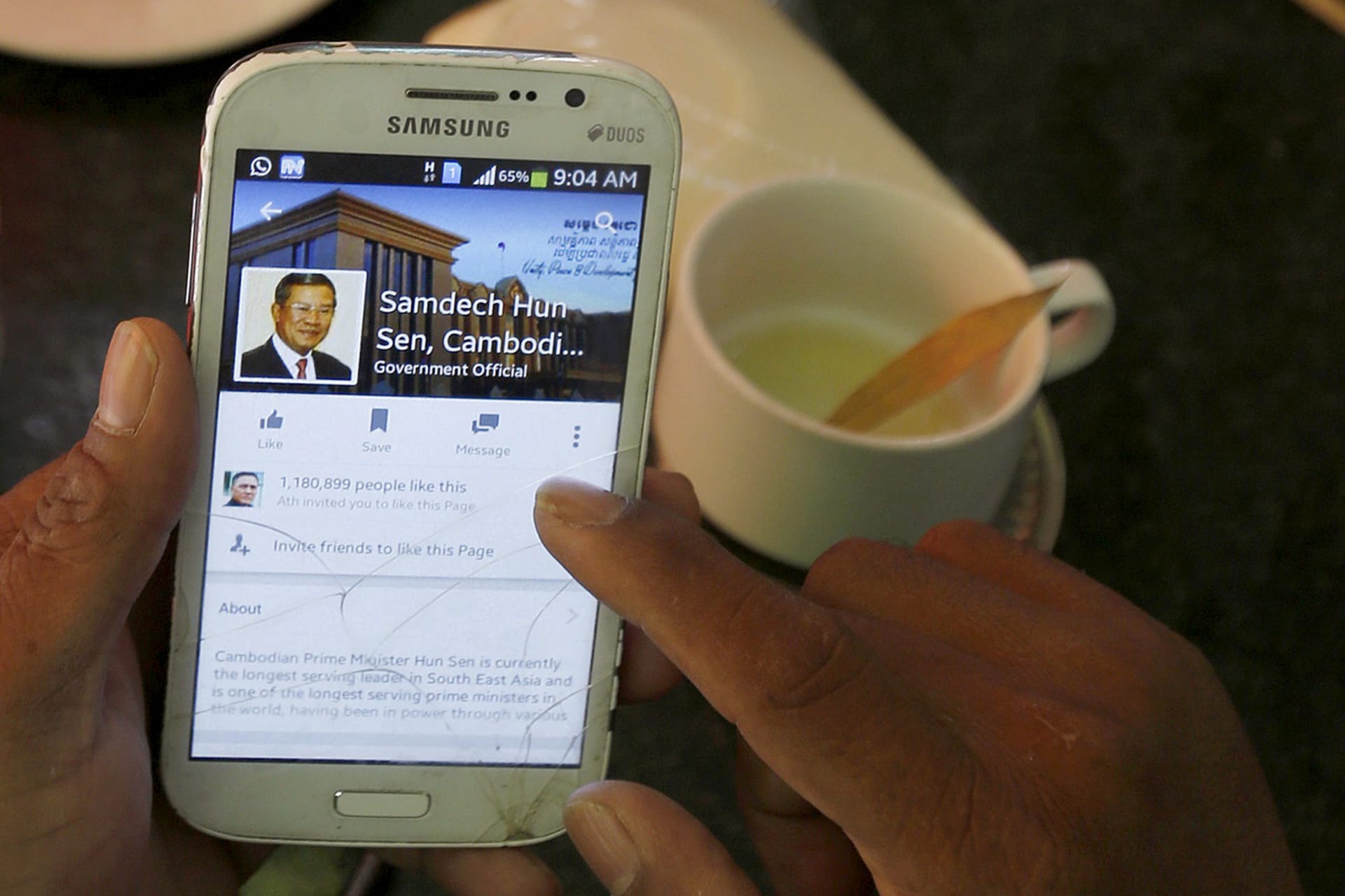 <p>A person uses a smartphone to look at the Facebook page of Cambodia’s Prime Minister Hun Sen.</p>
