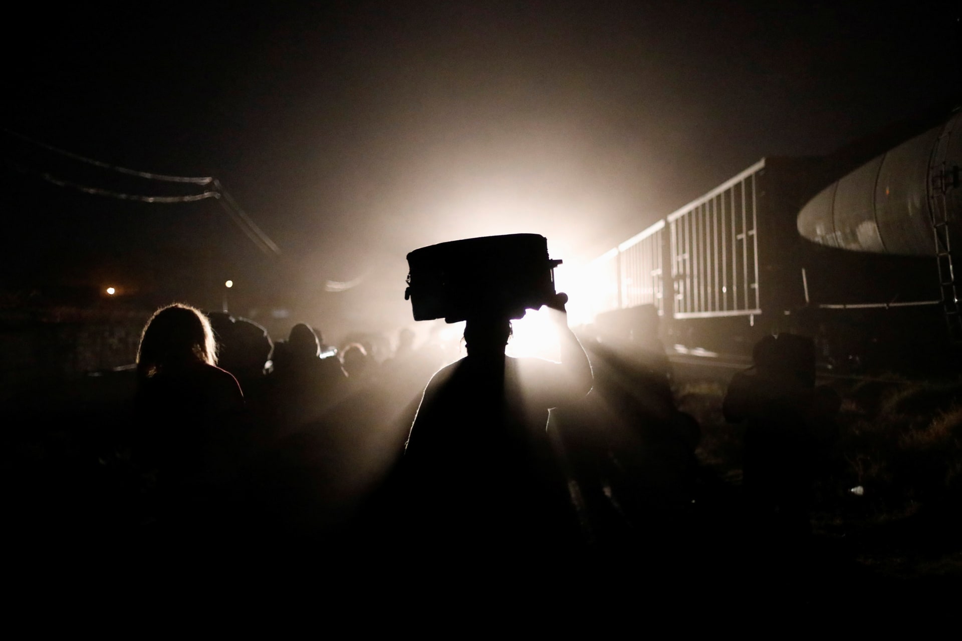 <p>A Central American migrant, moving in a caravan through Mexico, holds a bag as she and fellow migrants cross a railway line to stop a freight train and get on it, in Irapuato of Guanajuato State, on April 17, 2018.</p>
