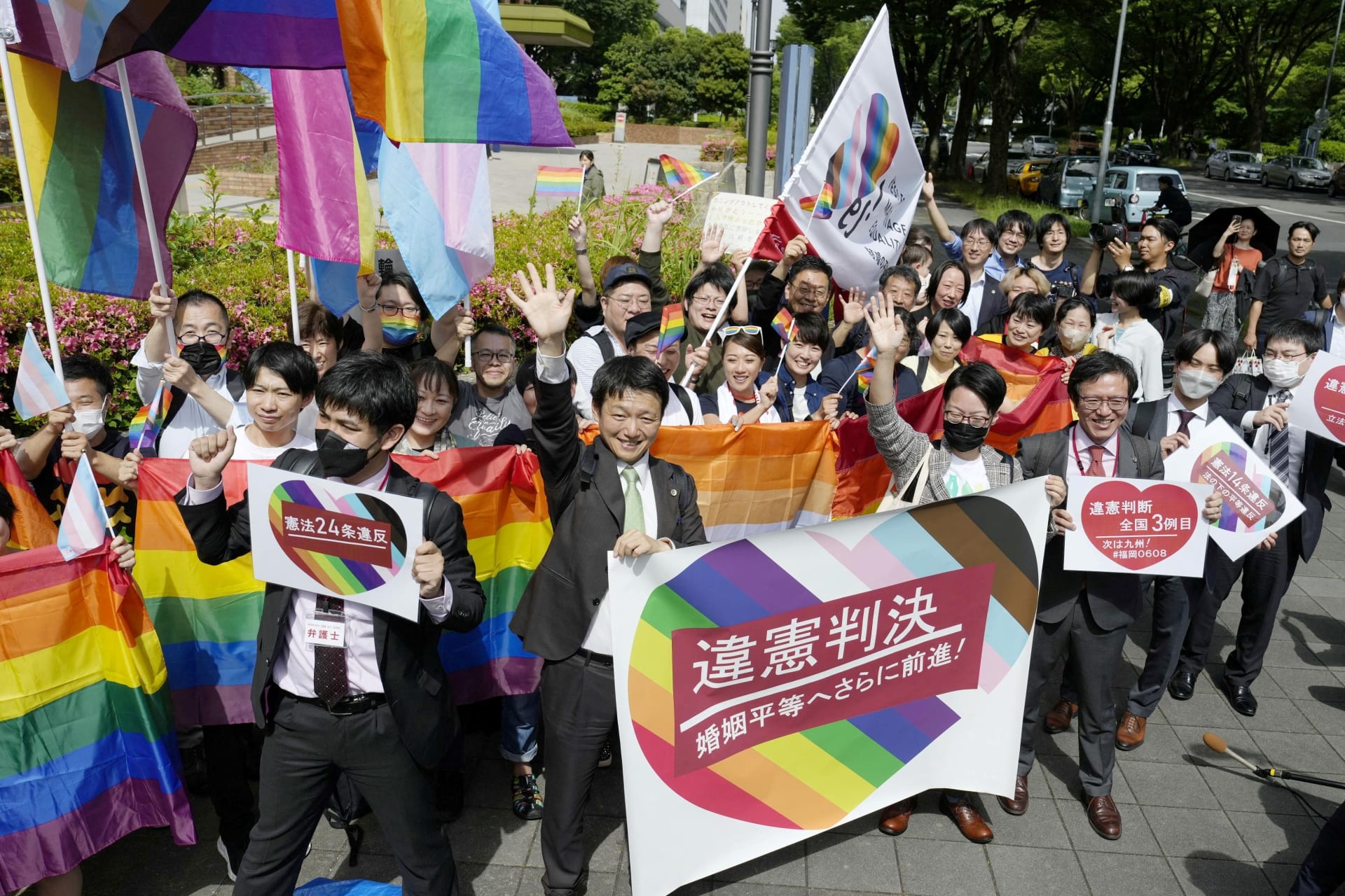 <p>People including plaintiffs’ lawyers hold banners and flags, after the lower court ruled that not allowing same-sex marriage was unconstitutional, outside Nagoya district court, in Nagoya, central Japan</p>
