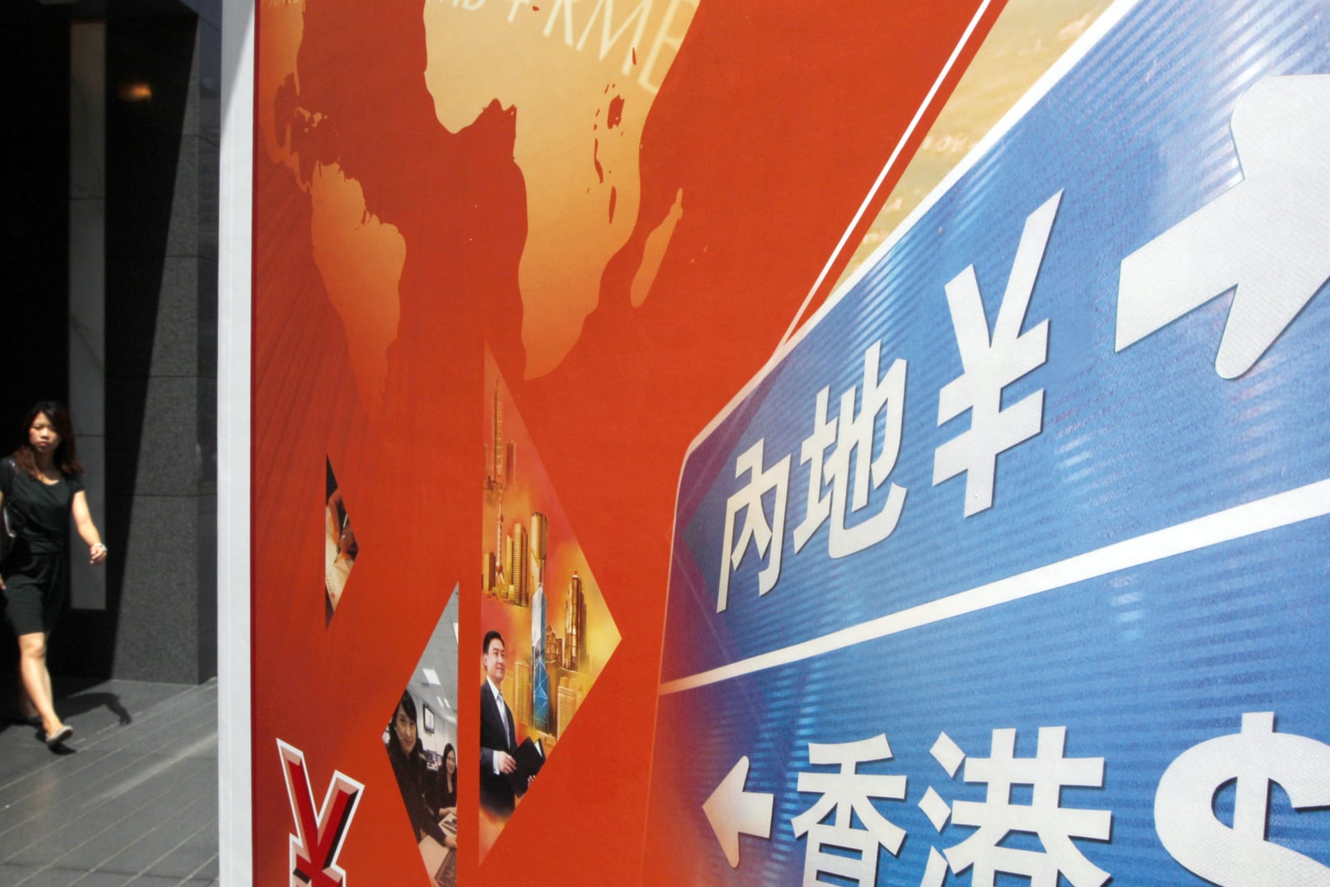 <p>A woman walks past an advertisement promoting China’s renminbi (RMB) or yuan services outside the Bank of China headquarters in Hong Kong on July 26,2011.</p>
