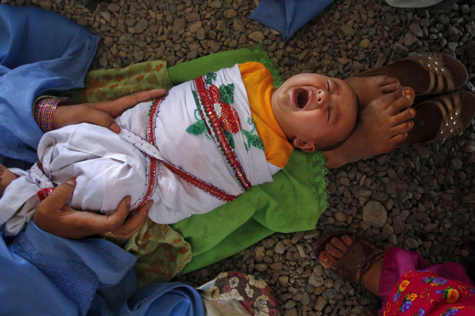 <p>An Afghan woman holds her son as they wait to go back to Afghanistan from a United Nations funded repatriation centre in the western city of Peshawar on May 31, 2012.</p>
