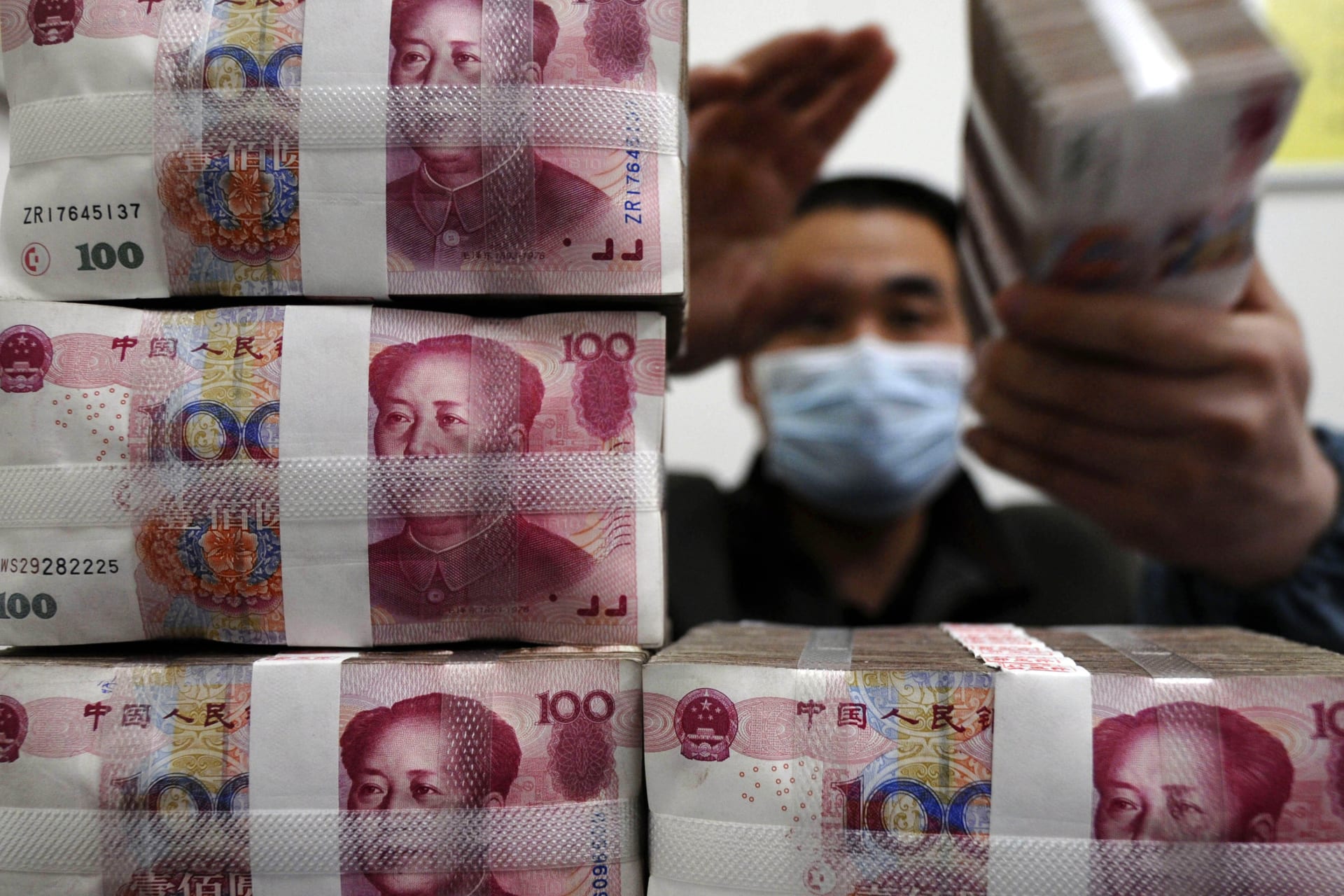 <p>An employee counts Renminbi banknotes at a branch of Bank Of China in Changzhi, Shanxi province on March 31, 2009.</p>

