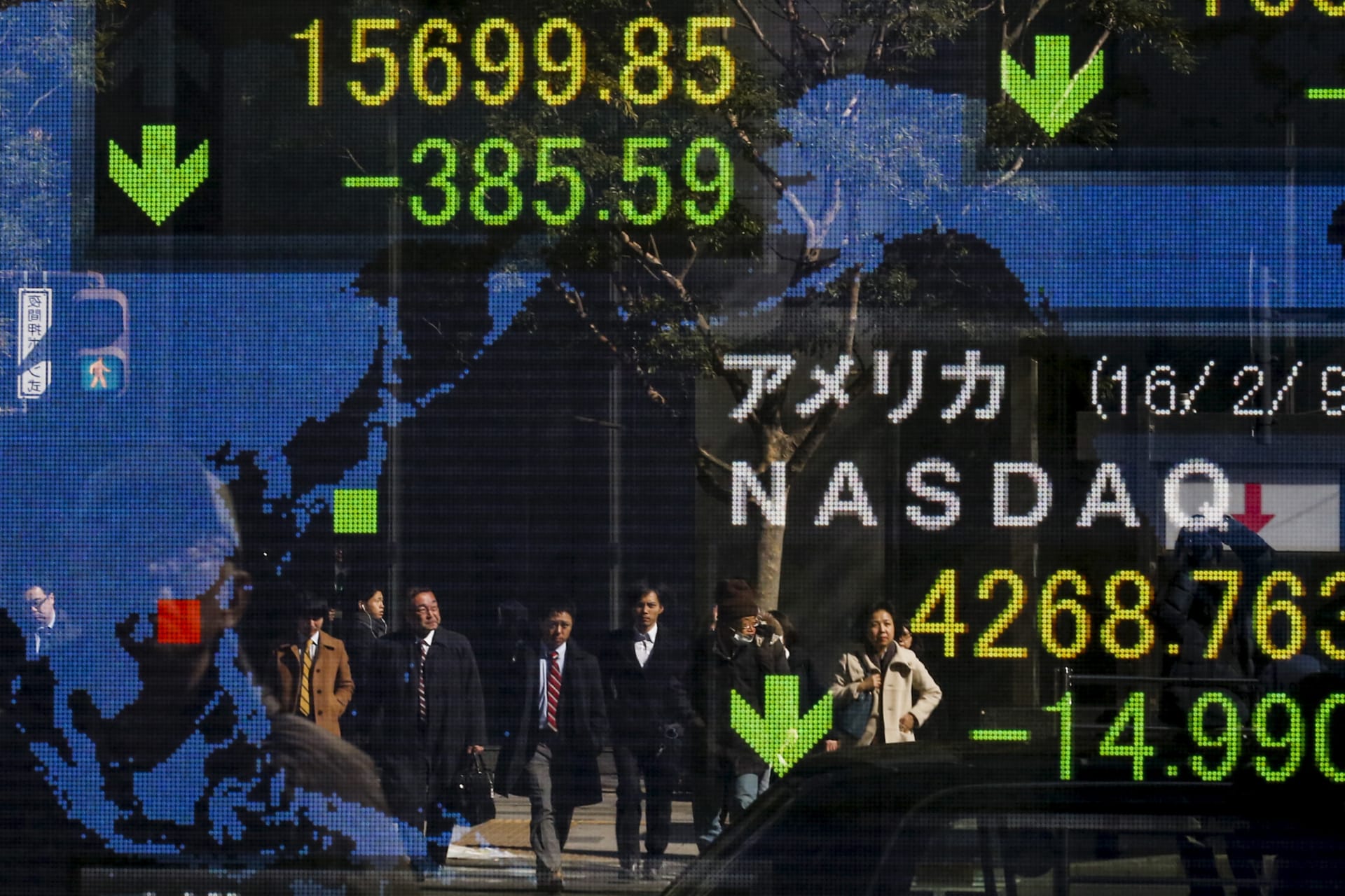 <p>People are reflected in a display showing market indices outside a brokerage in Tokyo, Japan, February 10, 2016.</p>
