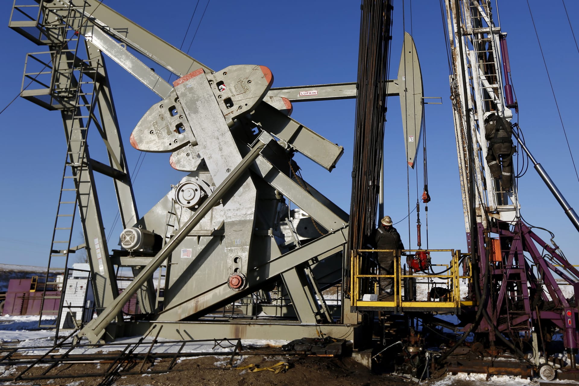 <p>A man climbs down an oil derrick on a rig of an oil drilling pump site in McKenzie County outside of Williston, North Dakota March 12, 2013.</p>
