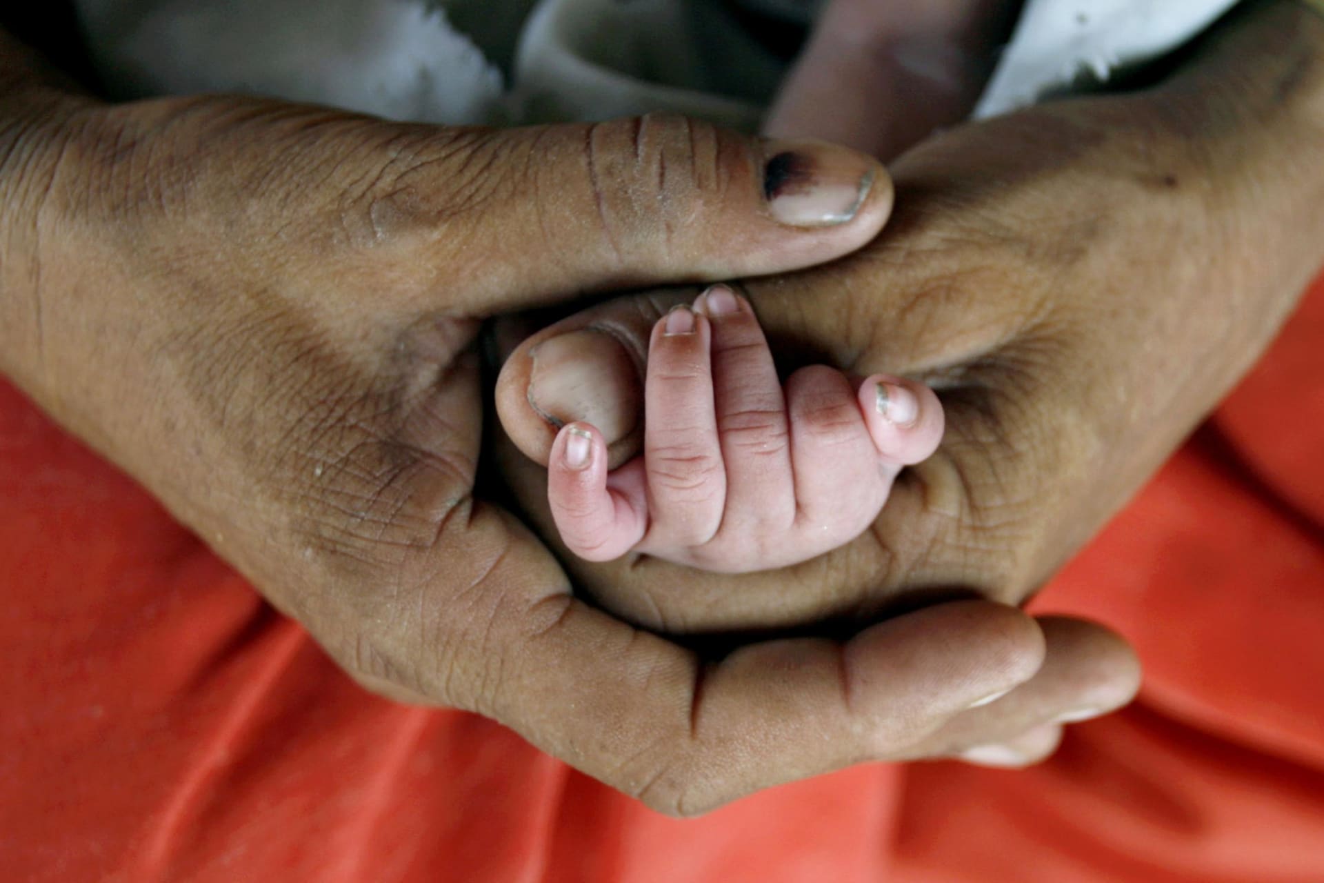 <p>Bismillah holds the hand of her newly born child as she feeds her in Akhera village in the northern Indian state of Haryana on July 4, 2007.</p>
