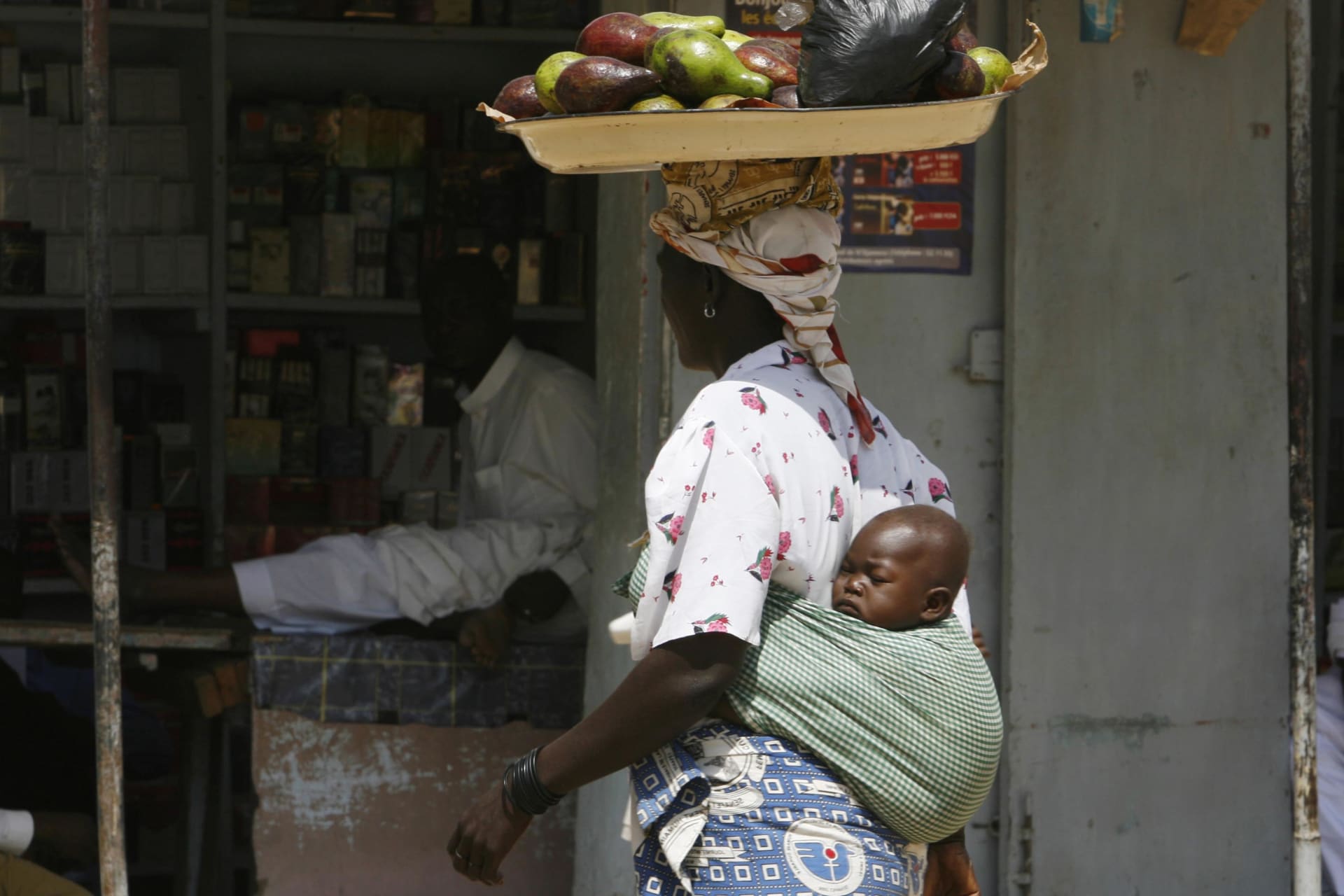 <p>A Chadian woman carries food on her head at a market in N’Djamena on November 6, 2007.</p>