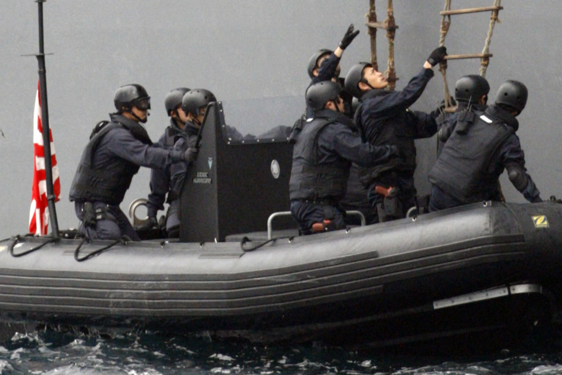 <p>Team members from Japan’s Maritime Self-Defense Forces board a boat to head to the U.S. navy transporter Harry Martin, playing the role of a vessel carrying suspected materials on October 13, 2007. </p>