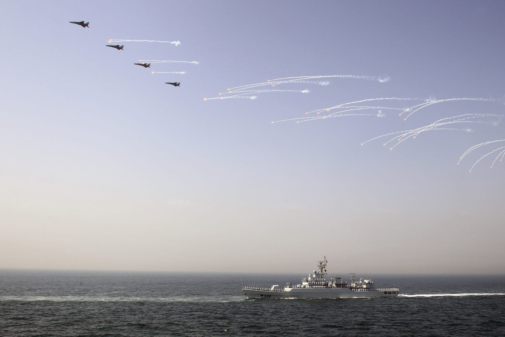 <p>Chinese jet fighters release flares as they fly over a Chinese vessel during the fleet’s review of the China-Russia joint naval exercise in the Yellow Sea on April 26, 2012.</p>
