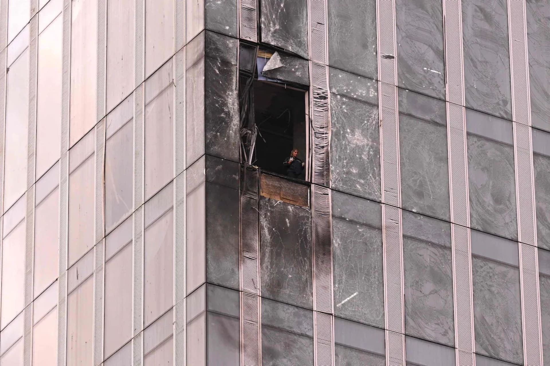 <p>A woman inspects some of the damage sustained to a building of the Moscow International Business Center after a drone attack in Moscow on Aug. 23. </p>
