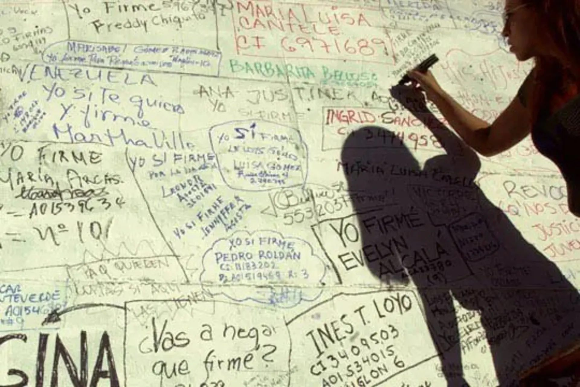 A Chavez opponent signs a petition demanding a recall referendum. 
