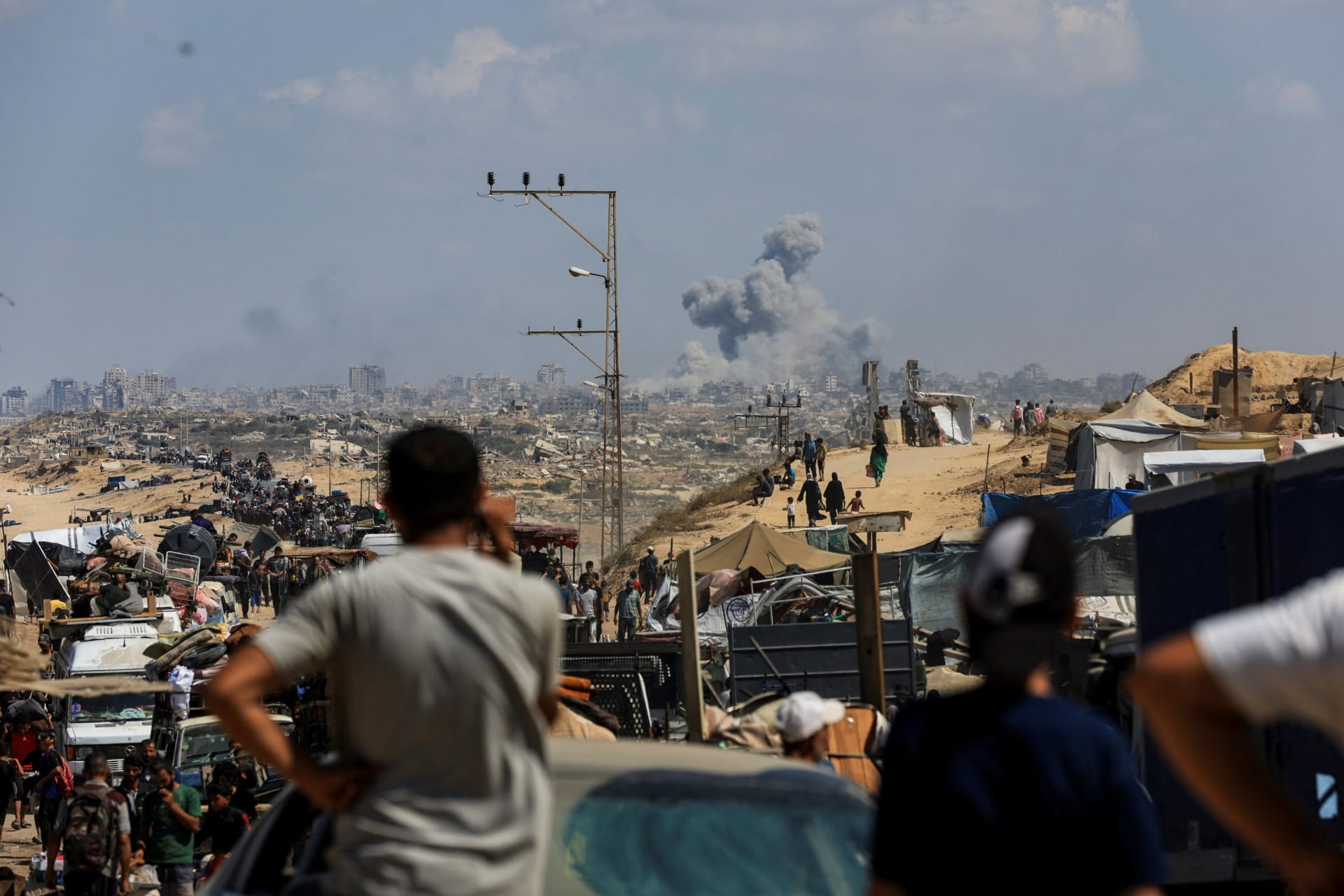 <p>Palestinians fleeing northern Gaza to escape an Israeli military operation watch smoke rising from Gaza City, September 24, 2025.</p>
