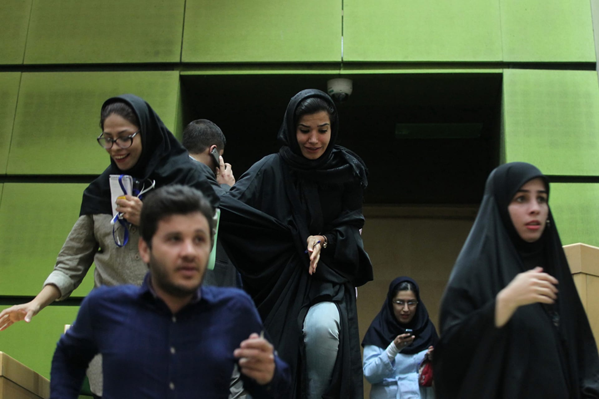 Staff exit Iran’s parliament building amid an attack in June 2017. 
