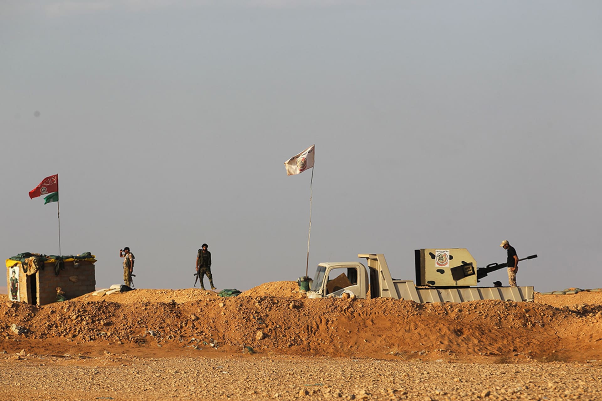 Iraqi Shiite fighters of the Hashed al-Shaabi paramilitary force stand guard on the border area with Syria. 