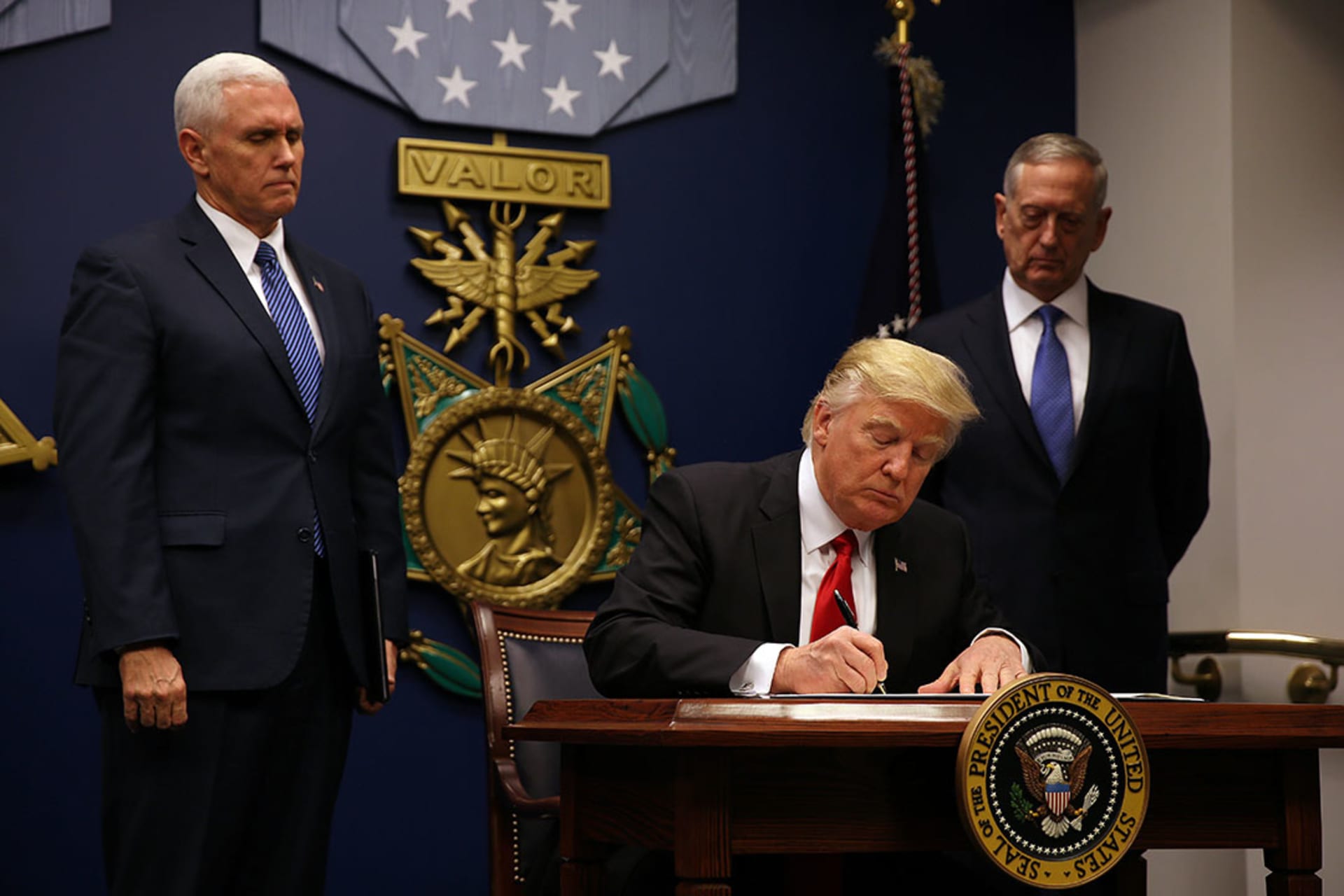 President Donald J. Trump signs an executive order on new immigration restrictions. Carlos Barria/Reuters