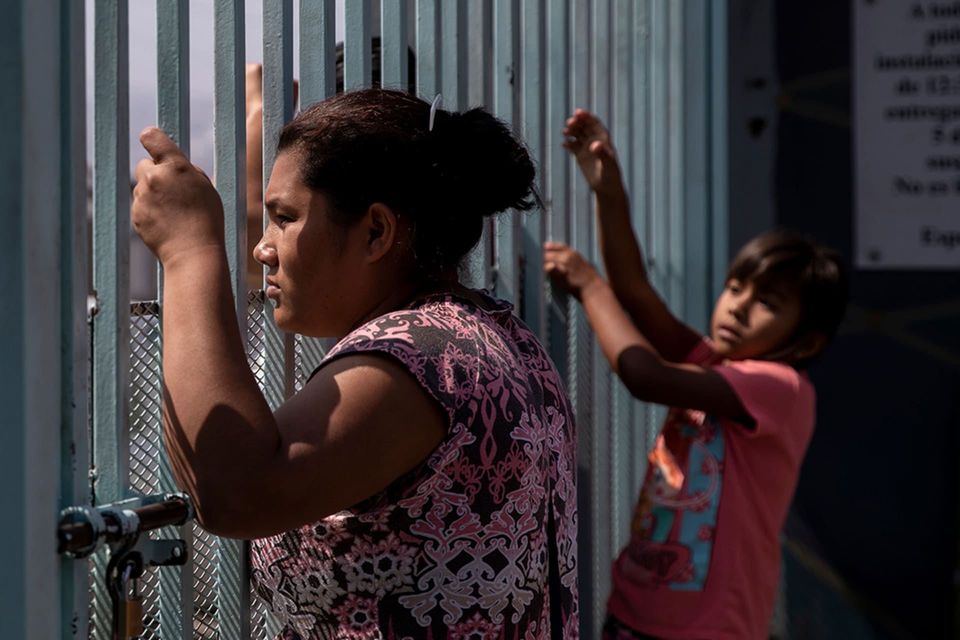 A Central American migrant looks on from a fence at a shelter for migrant women and children in Tijuana, Mexico. Eduardo Jaramillo Castro/AFP/Getty Images