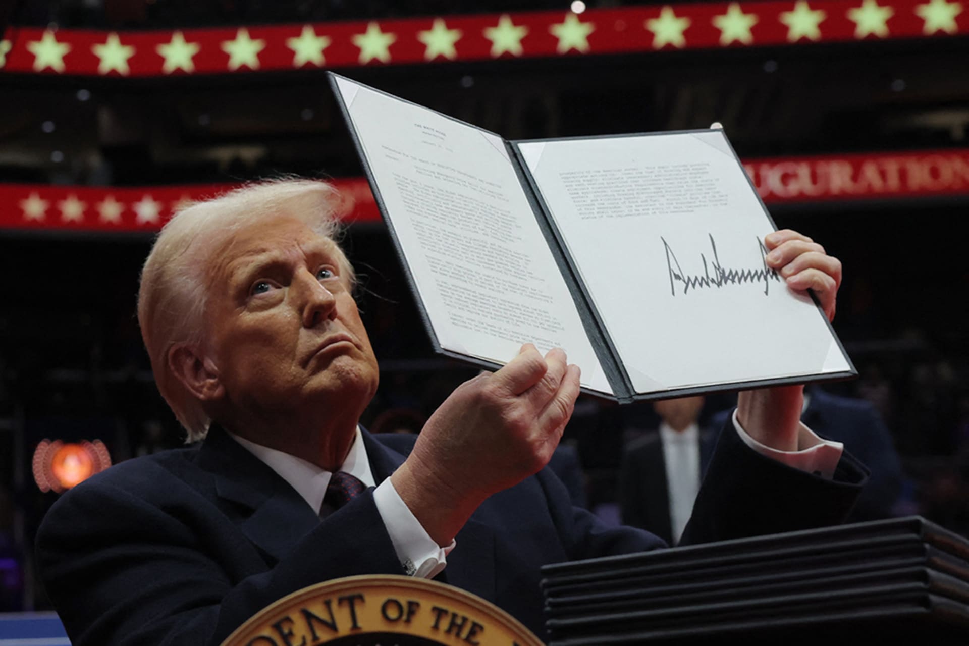 President Donald Trump presents an executive order during his inaugural parade inside the Capital One Arena in Washington, DC. Carlos Barria/Reuters