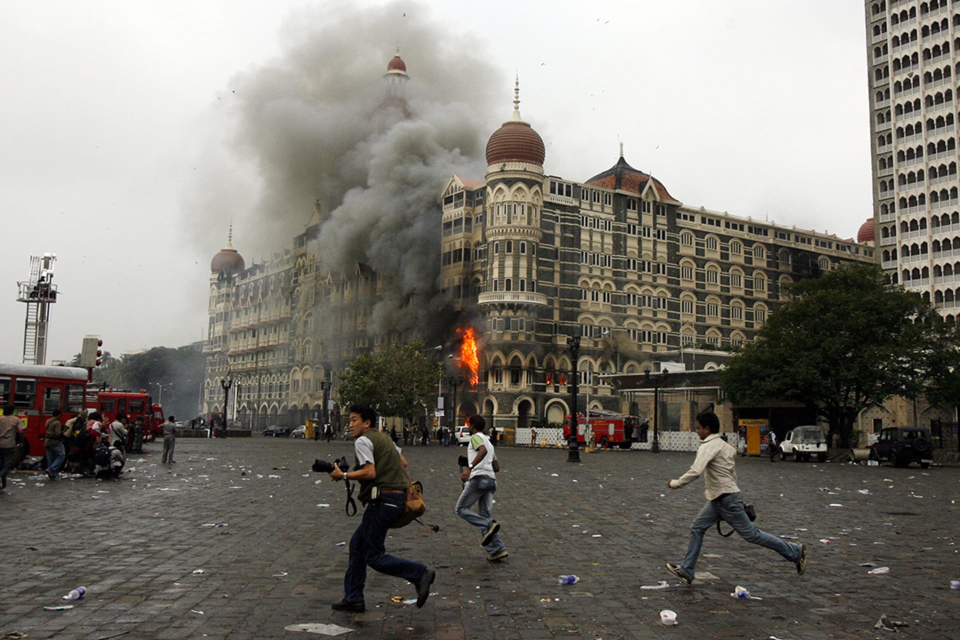 Photographers run past a burning Taj Mahal Hotel. Punit Paranjpe/Reuters