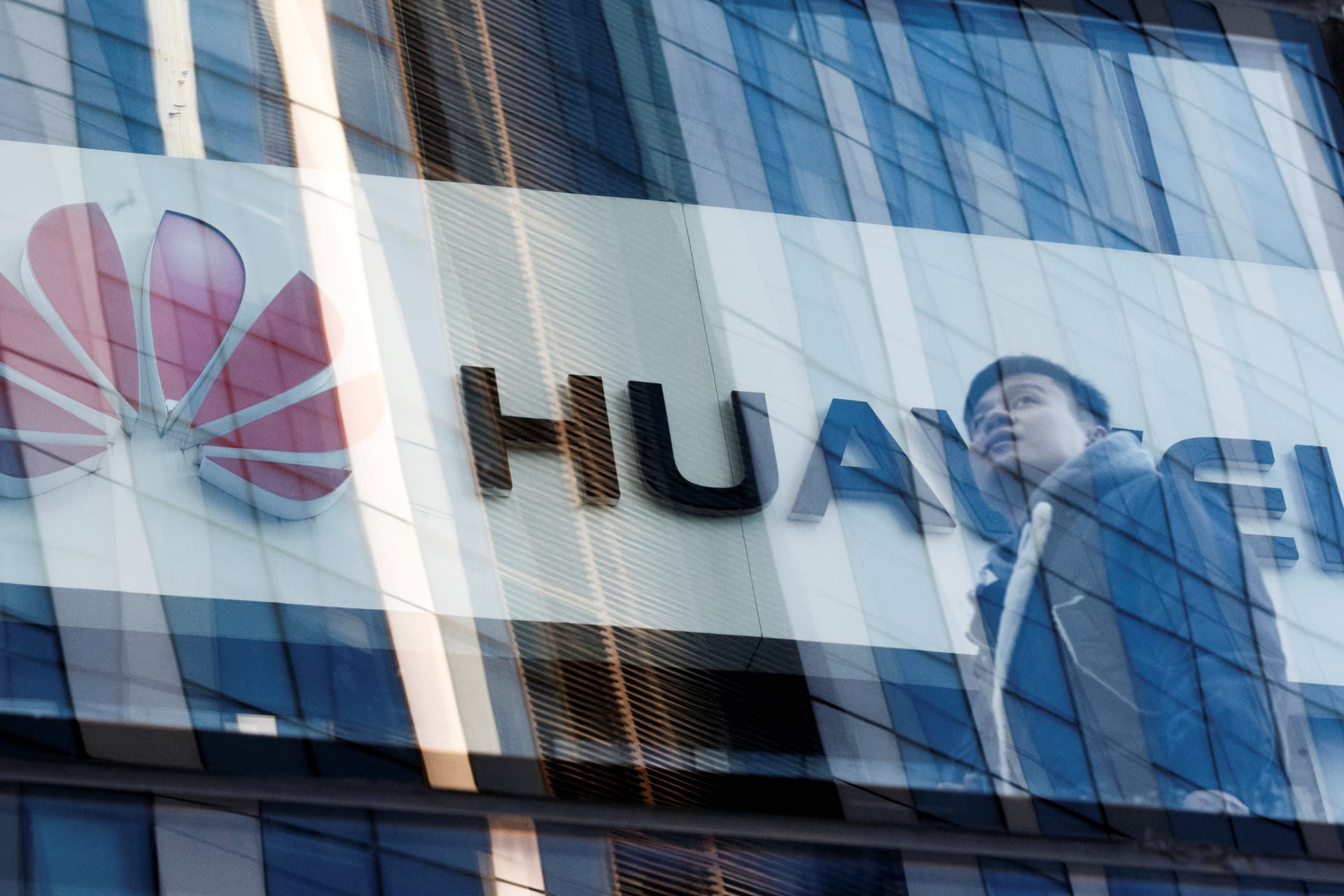 <p>A man walks past Huawei offices in Beijing.</p>