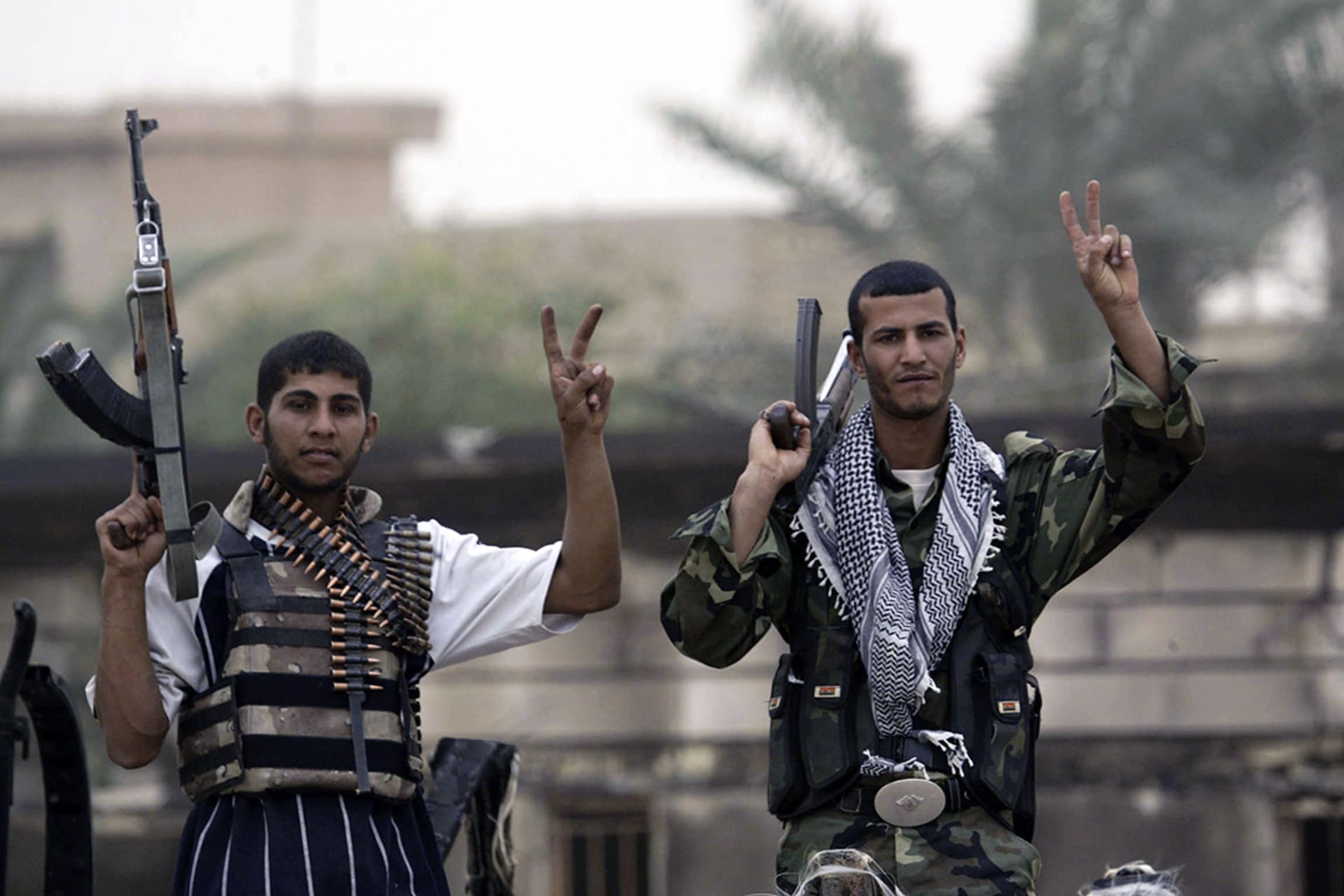 In Basra, fighters loyal to cleric Muqtada al-Sadr flash the victory sign in Basra.
