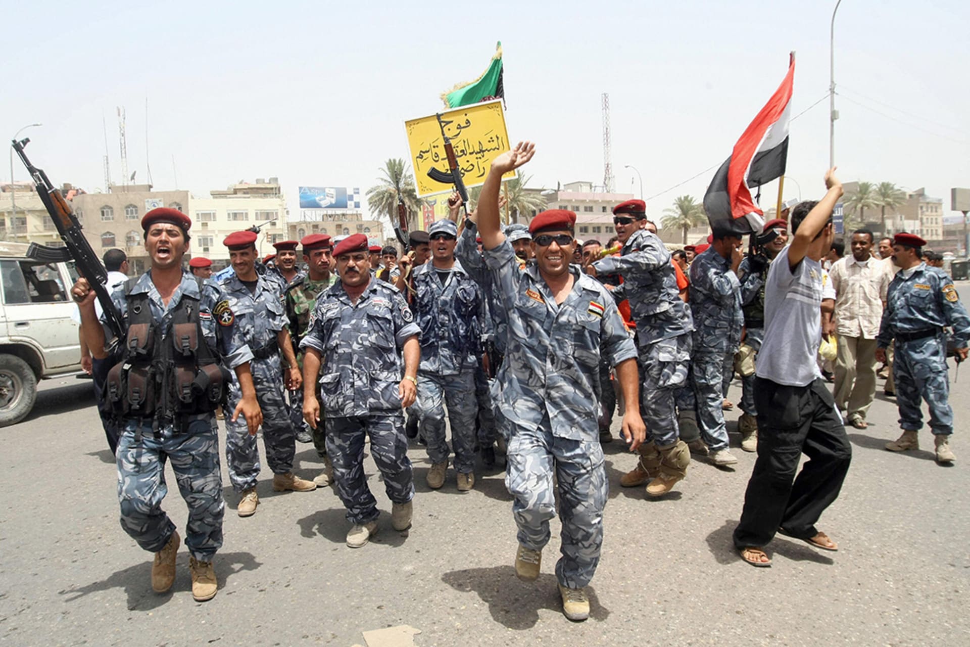 Iraqi police and soldiers celebrate on the streets of Basra after U.S. troops withdraw towns and cities across Iraq. 
