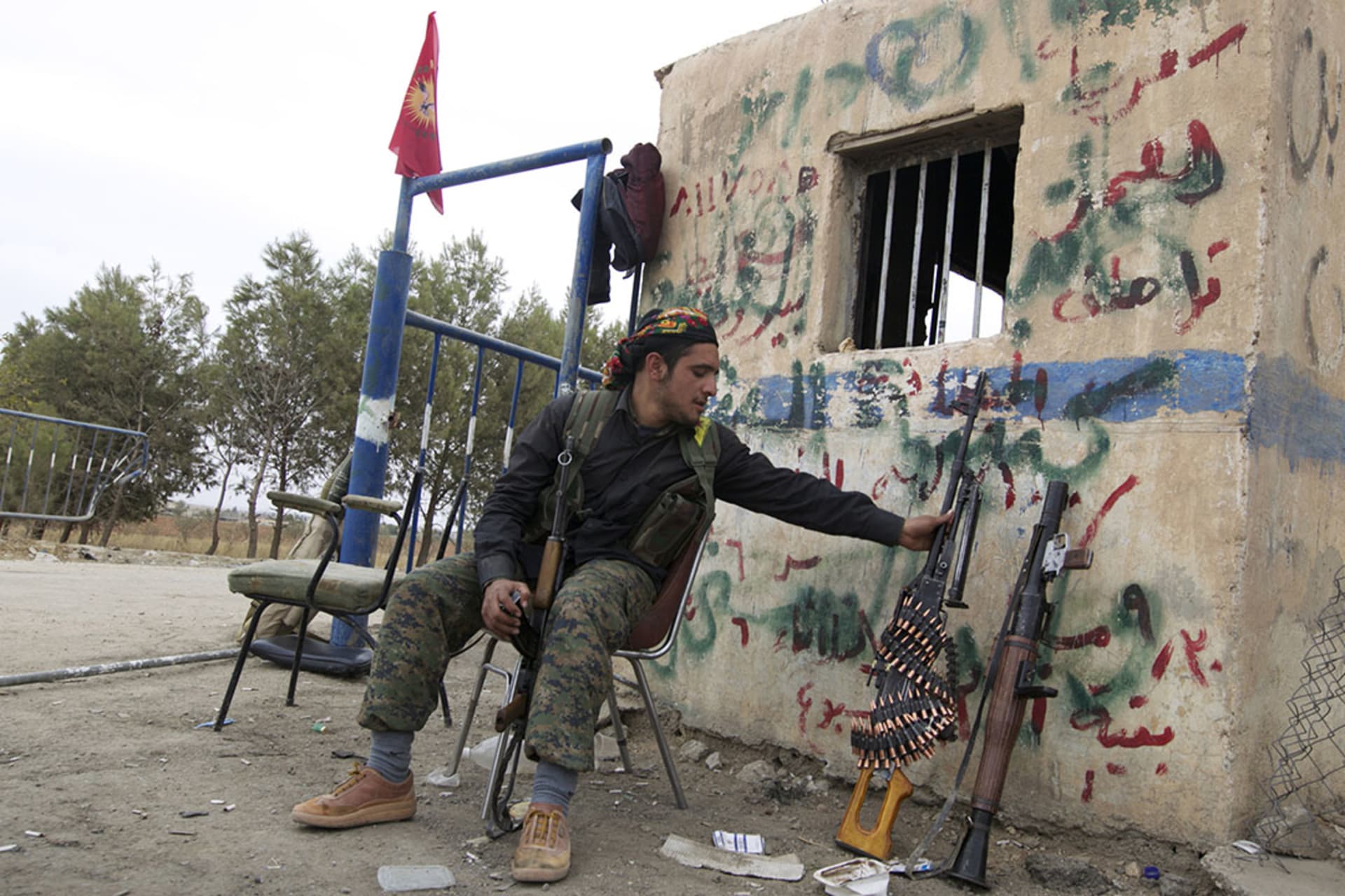A YPG fighter sits at a checkpoint near Ras al-Ain in Syria. Kurdish militias captured the city and its surrounding villages, leading to the declaration of autonomy.
