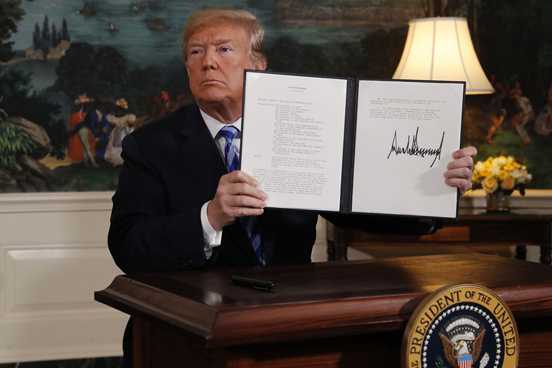 U.S. President Donald J. Trump displays a presidential memorandum after announcing his intent to withdraw from the Iran nuclear agreement. 