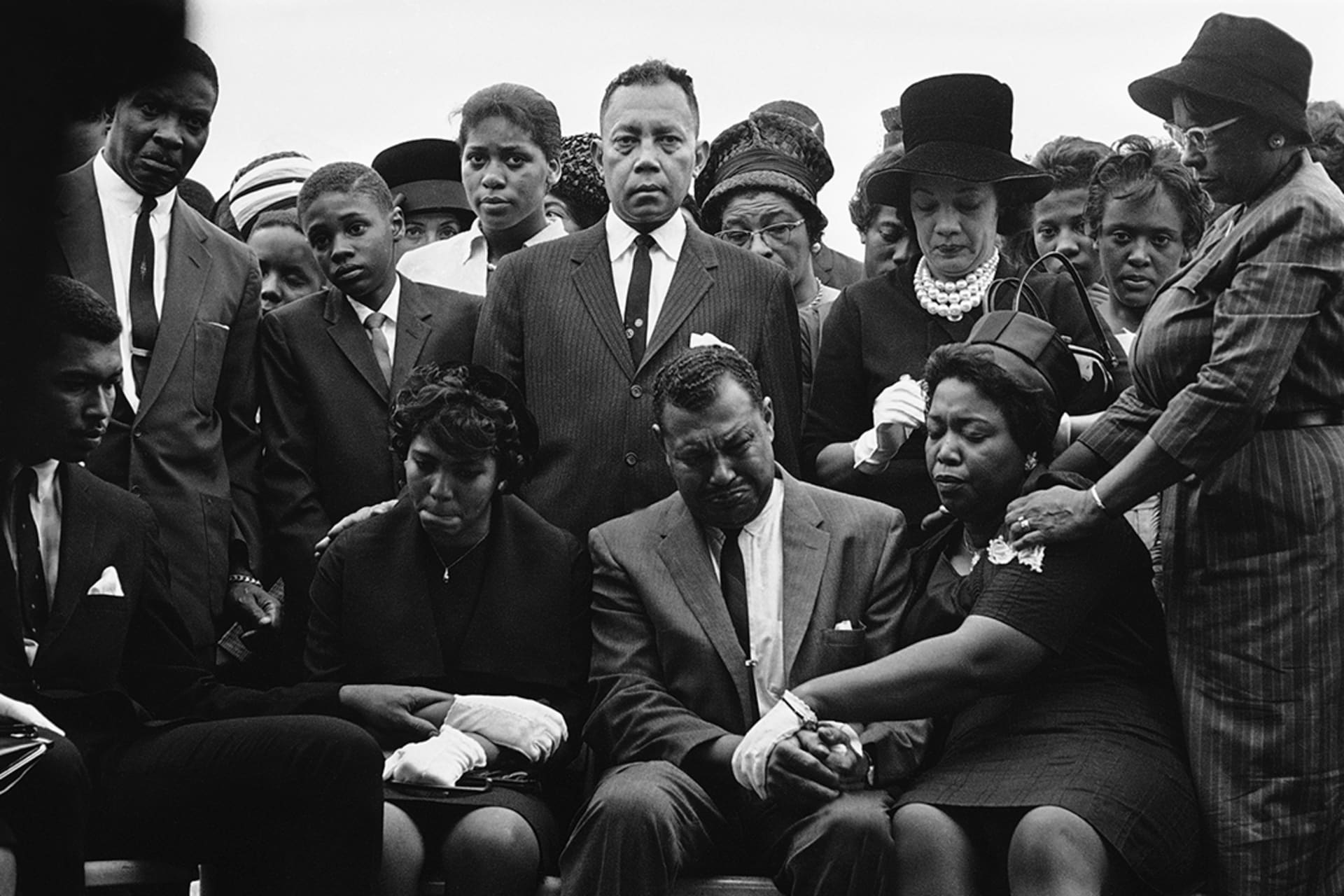 The family of Carol Robertson, a fourteen-year-old African American girl killed in the bombing of Sixteenth Street Baptist Church, mourn at her graveside during funeral services. 
