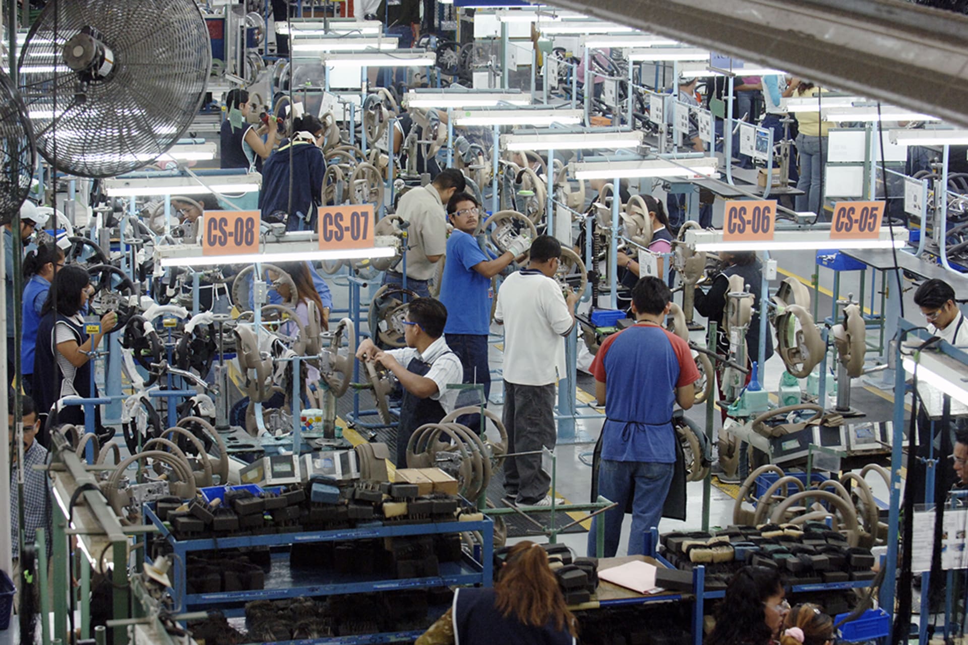 Mexican workers produce steering wheels at Delphi Delco Electronics, a maquiladora plant that builds parts for General Motors. Robert Daemmrich Photography Inc/Corbis/Getty Images
