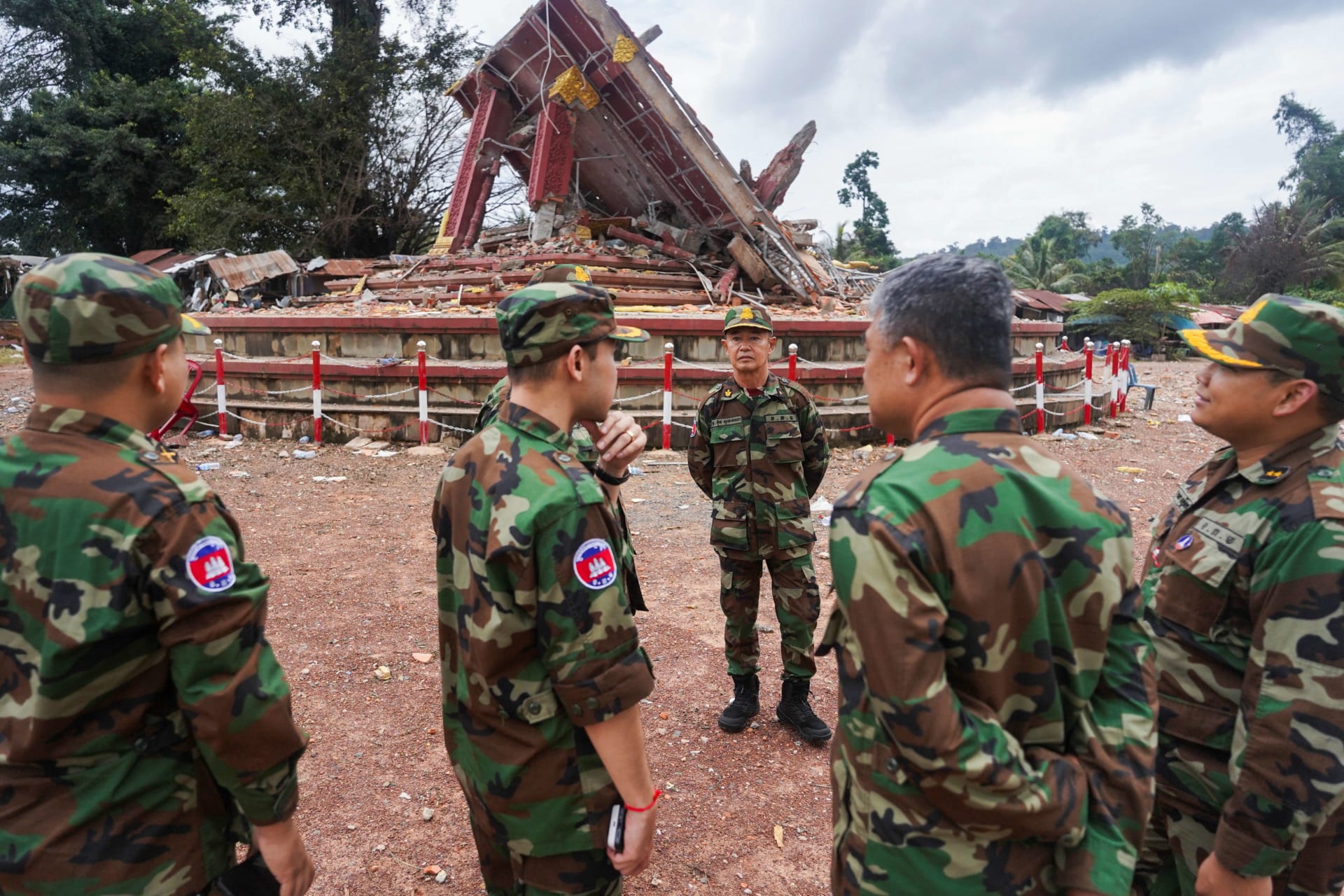 <p>Military personnel stand near a destroyed monument at the closed An Ses border checkpoint, also known as Chong Arn Ma in Thai, in Cambodia on August 4. </p>
