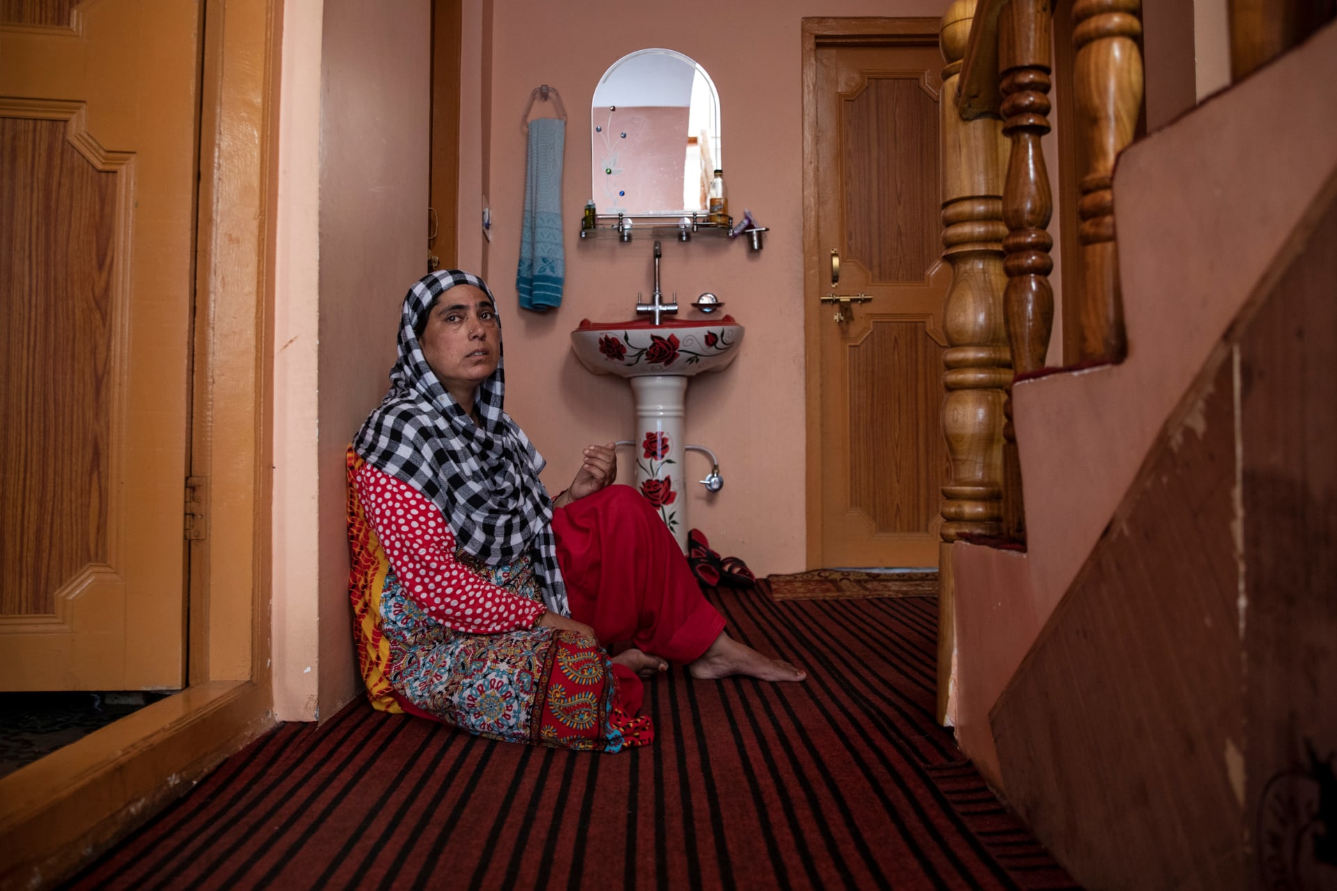 <p>A woman sits in the doorway of her home in Pulwama.</p>
