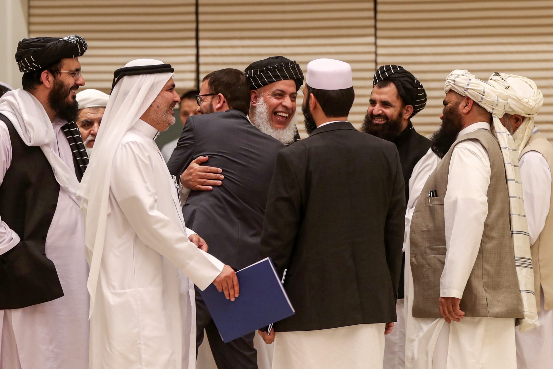<p>Taliban negotiator Abbas Stanikzai embraces a man during the second day of the Intra Afghan Dialogue talks in Doha.</p>
