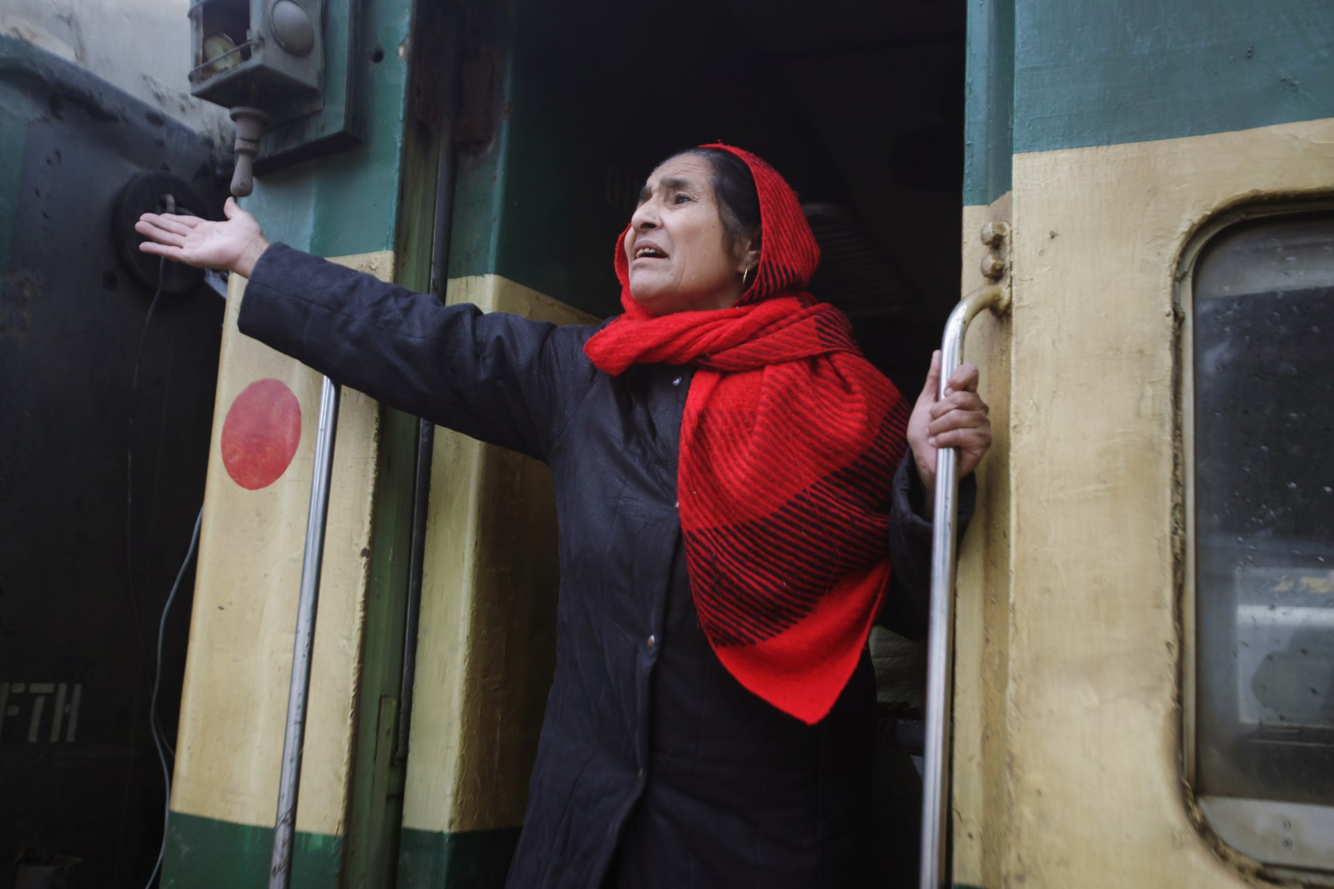 <p>An Indian woman gestures to her relatives as she leaves a railway station in Lahore, Pakistan.</p>
