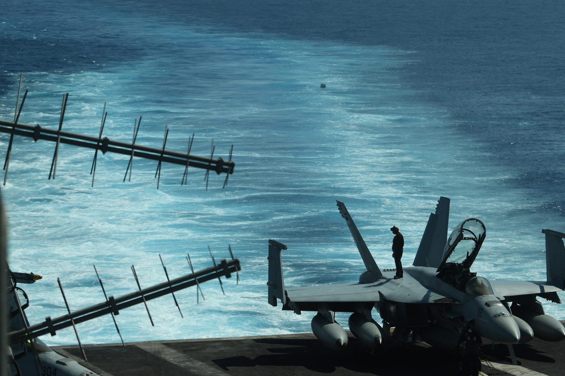 <p>A sailor inspects atop an FA-18 hornet fighter jet during a routine training aboard US aircraft carrier Theodore Roosevelt in the South China sea on April 10, 2018. </p>
