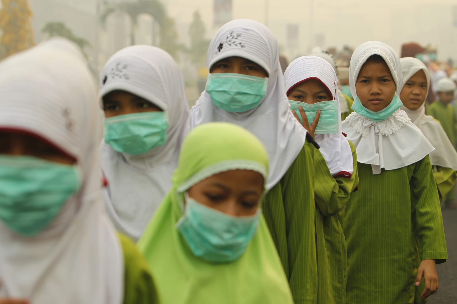 <p>Muslim students wearing masks walk in Dumai, on Indonesia’s Riau province in Sumatra, June 23, 2013.</p>