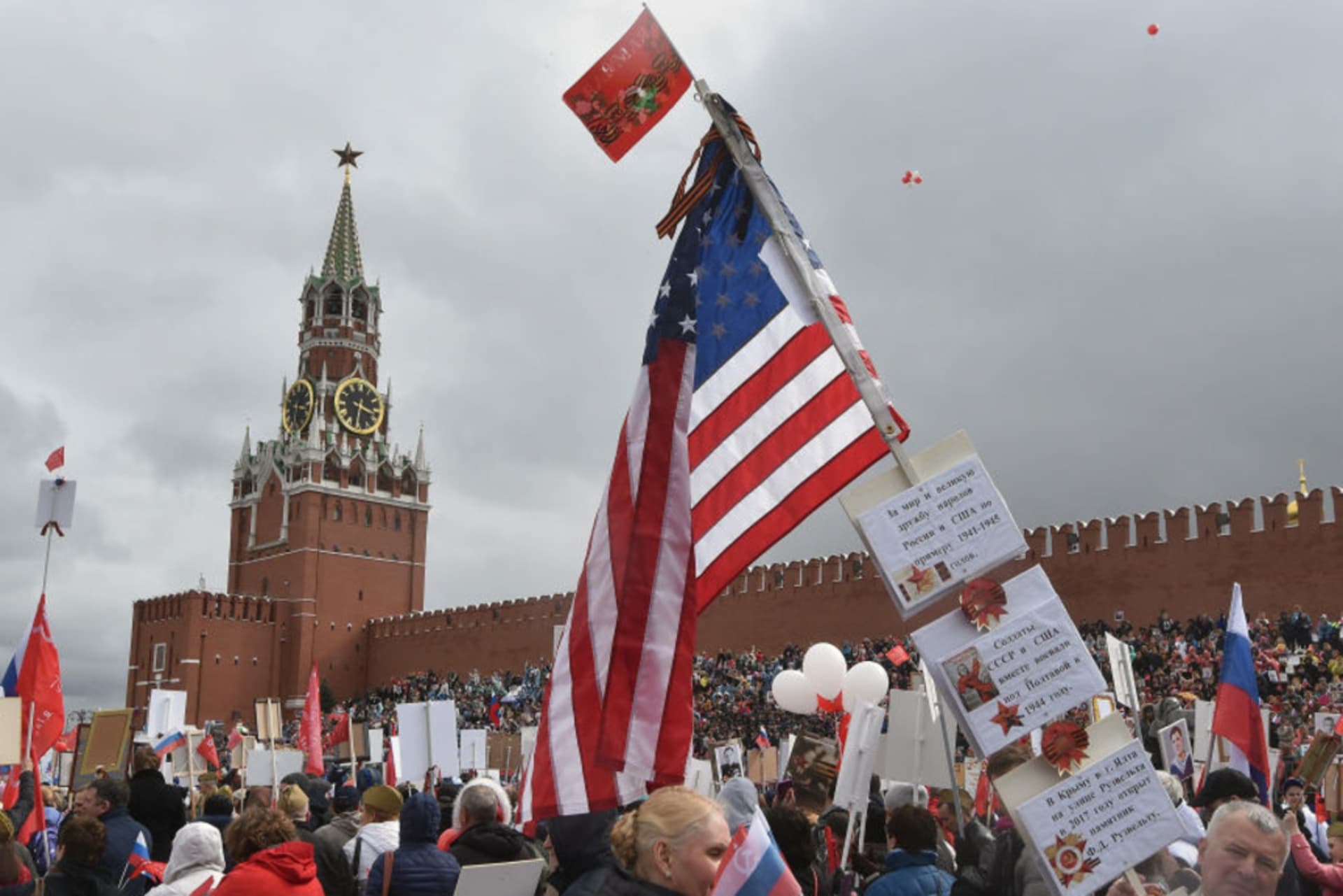 <p>People carry portraits of relatives who fought in World War II and the U.S. flag to mark the Allied victory in World War II, with the Kremlin in the background on May 9, 2017 in Moscow, Russia. </p>
