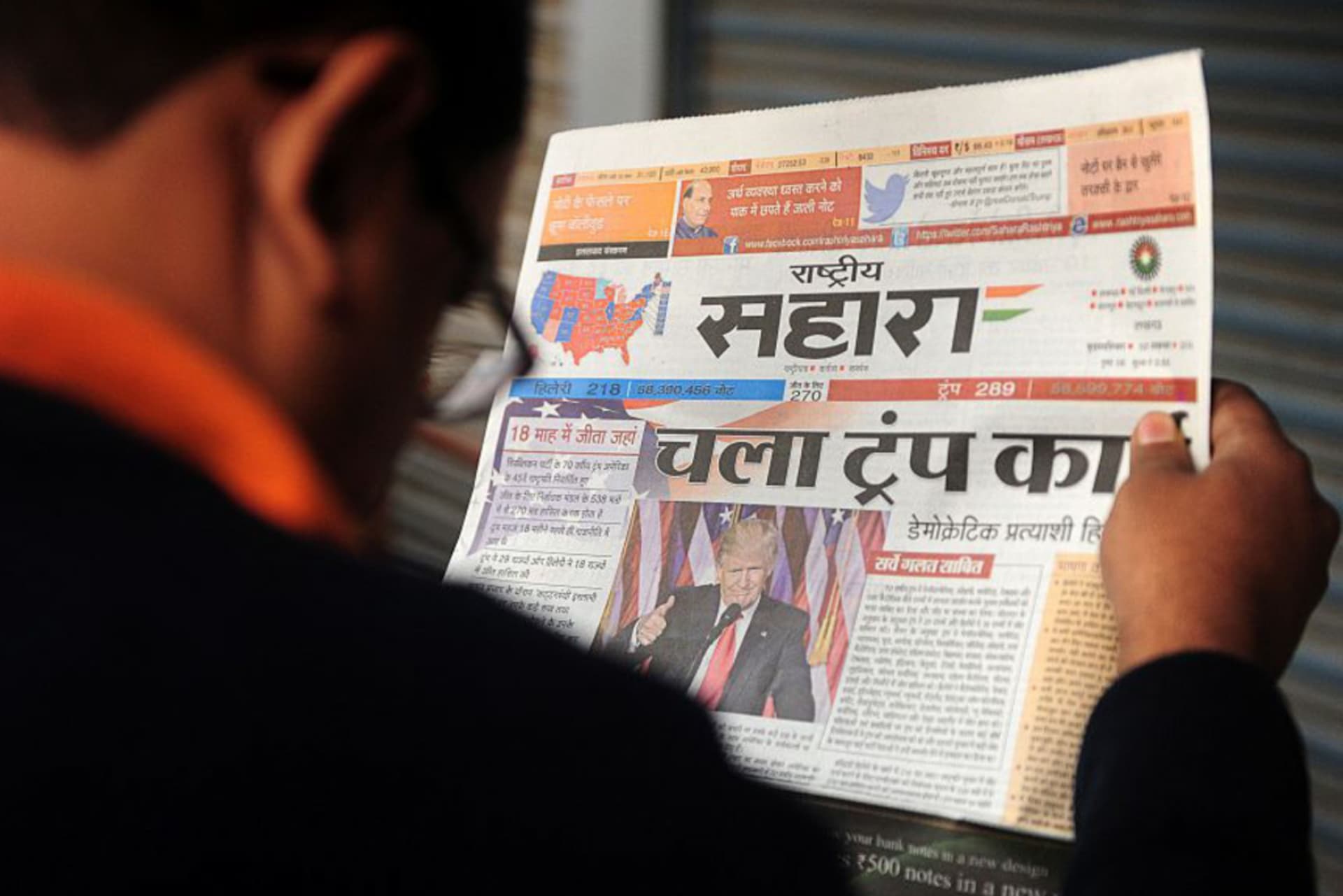 <p>An Indian man reads a newspaper article about newly elected U.S. President Donald J. Trump, on a street in Allahabad. </p>