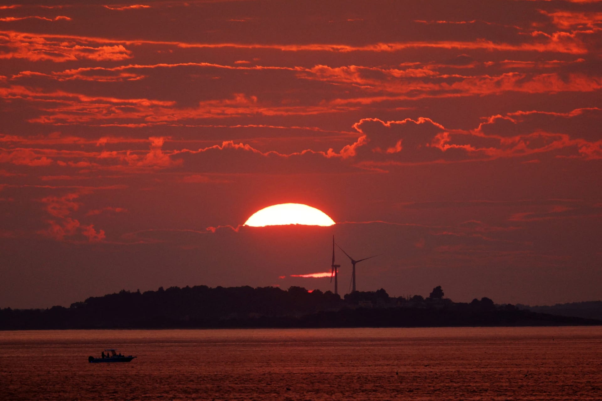 <p>The sun sets behind a pair of wind turbines in Newburyport, Massachusetts, U.S. on August 25, 2024.</p>