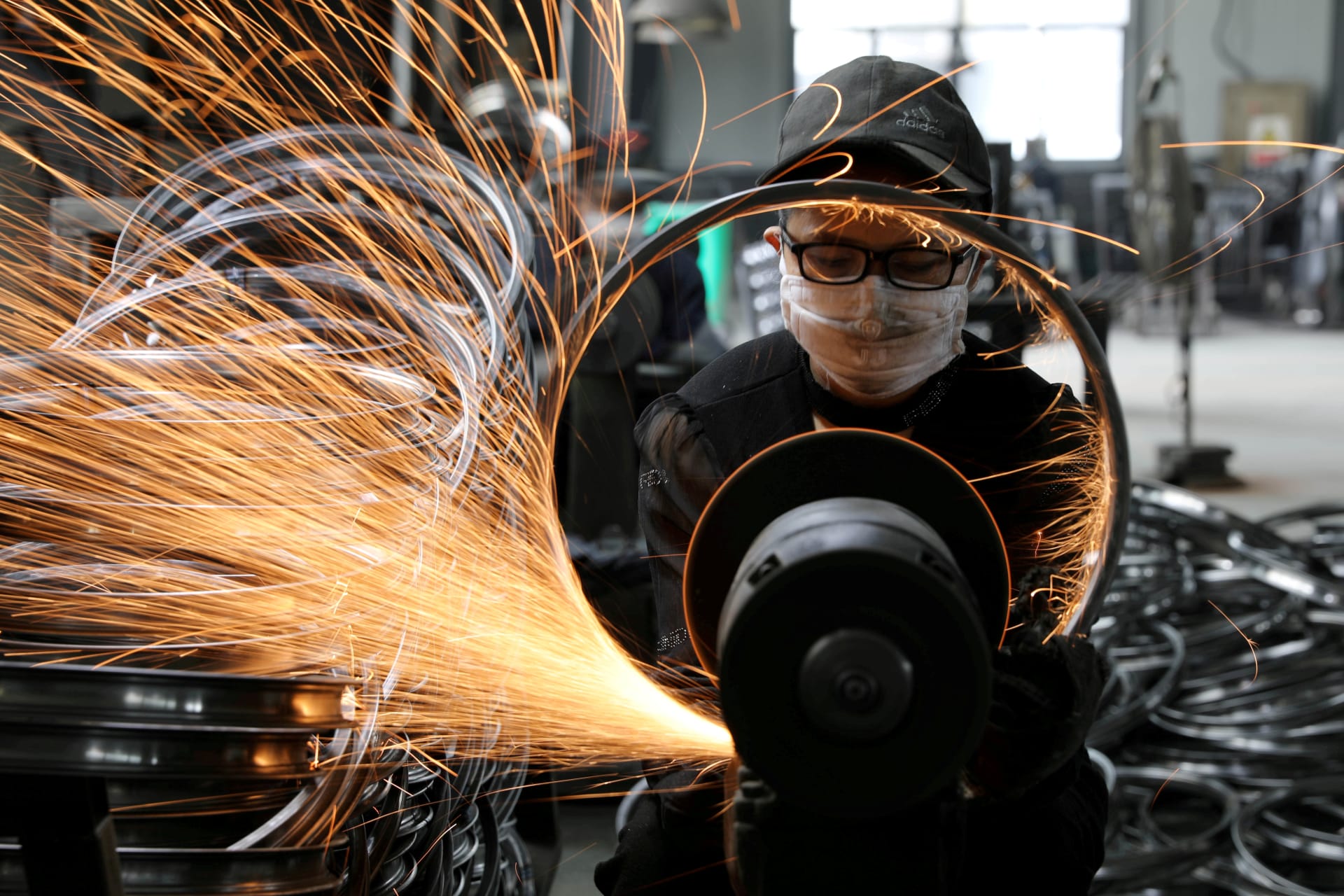<p>A worker polishes a bicycle steel rim at a factory manufacturing sports equipment in Hangzhou, China on September 2, 2019.</p>