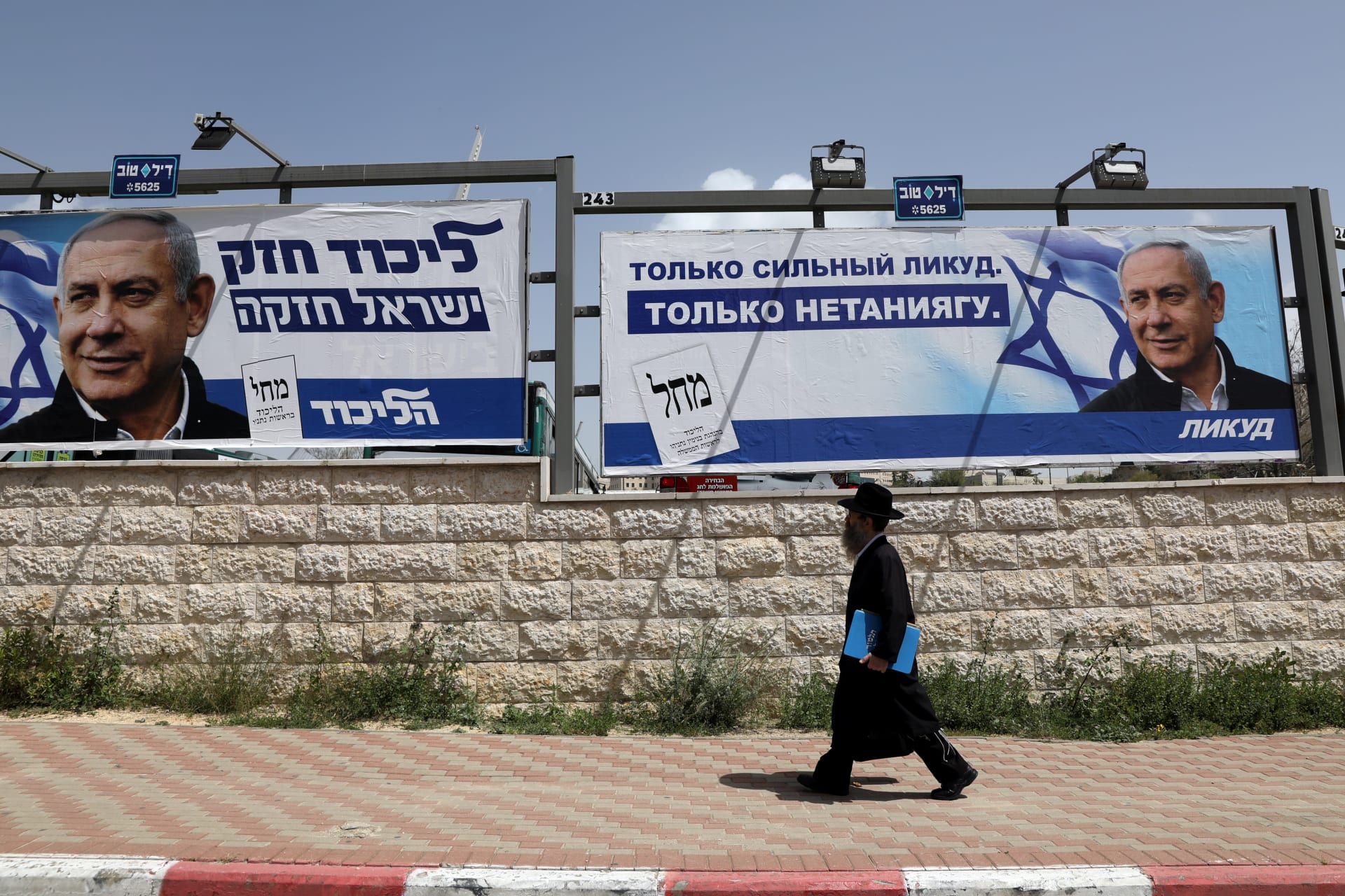 <p>An Orthodox Jewish man walks past an election campaign poster in Jerusalem.</p>
