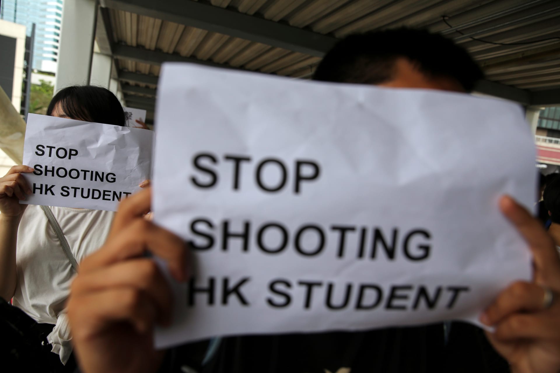 <p>Protesters hold signs following a day of violence in Hong Kong.</p>