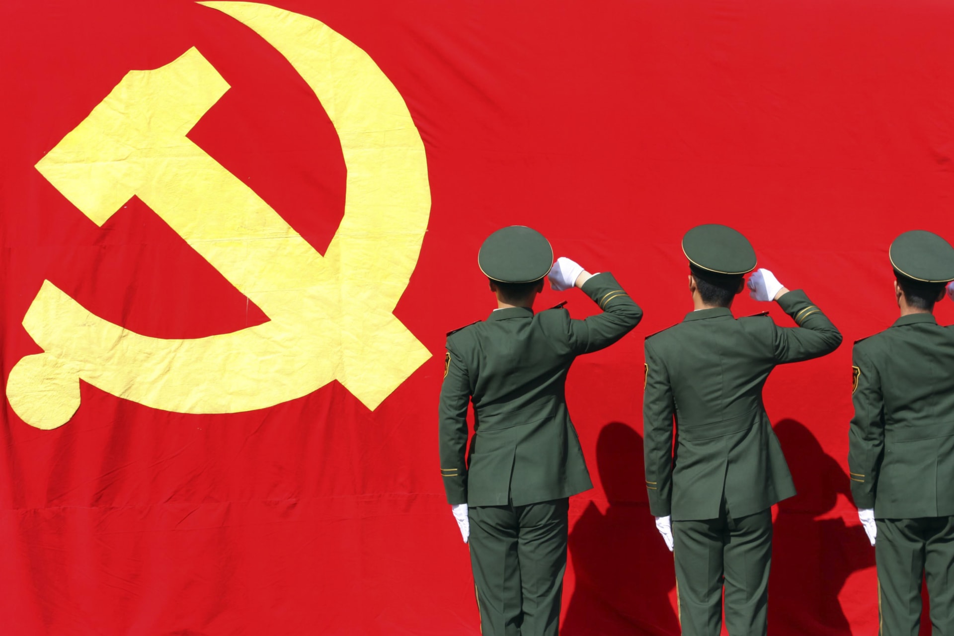 <p>Paramilitary policemen hold their fists in front of a flag of Communist Party of China as they attend an oath-taking rally to ensure the safety of the upcoming 18th National Congress of the Communist Party of China (CPC), at a military base in Hangzhou, Z</p>
