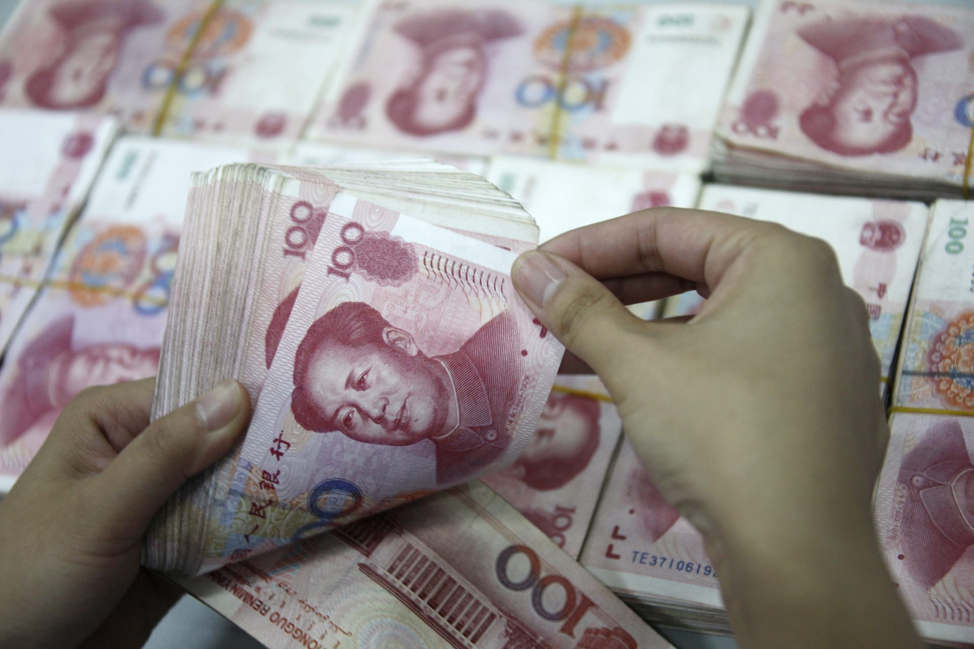 <p>An employee counts Yuan banknotes at a branch of Industrial and Commercial Bank of China in Huaibei, Anhui August 3, 2010. </p>