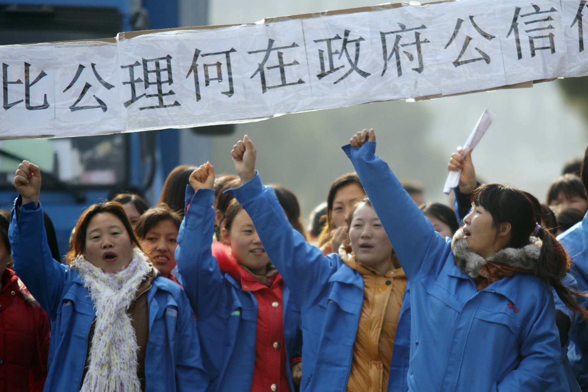 <p>Workers on strike blocking the entrance gate of Hi-P International factory yell slogans during a protest in Shanghai in December 2011.</p>
