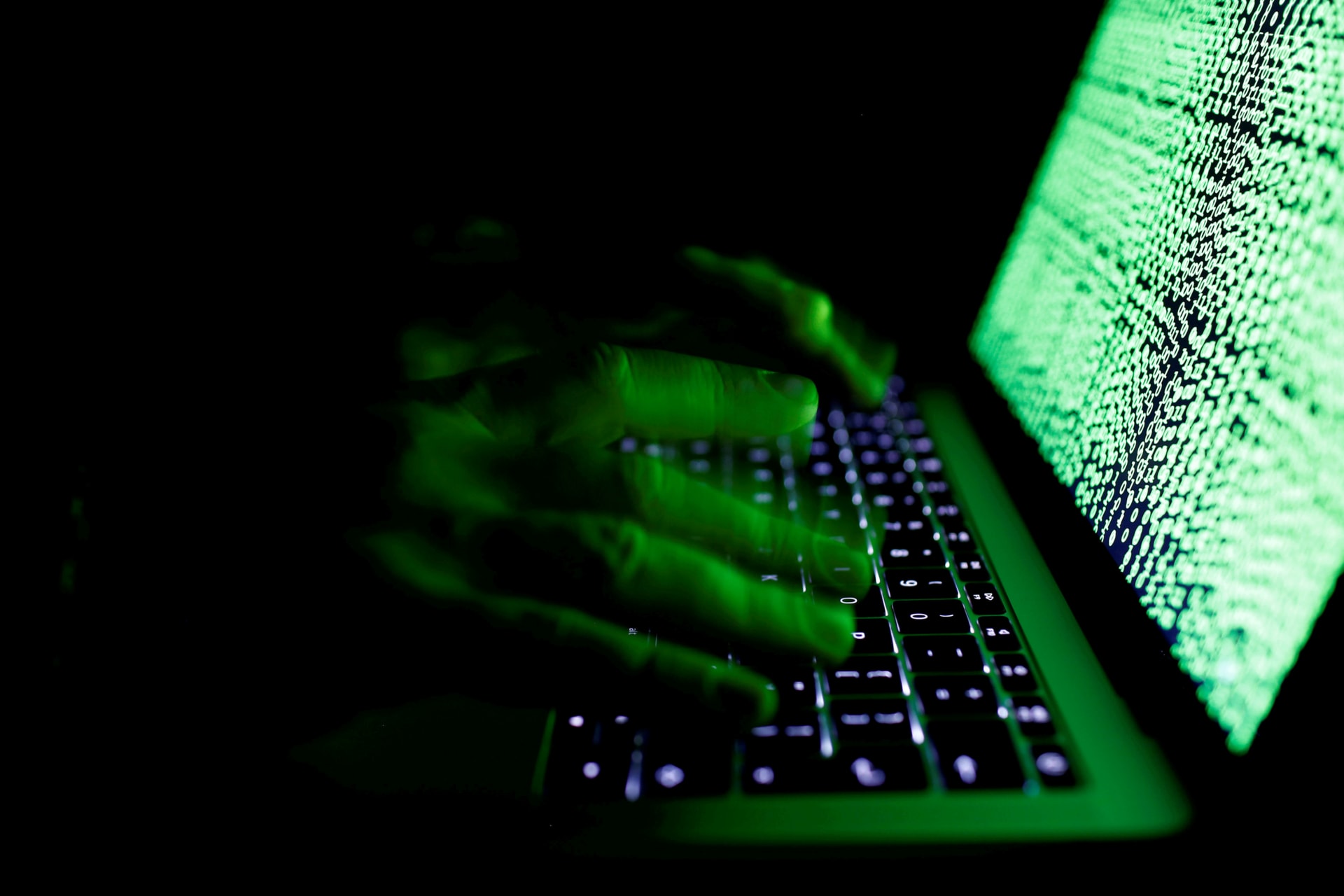 <p>A man types on a computer keyboard in front of the displayed cyber code. </p>