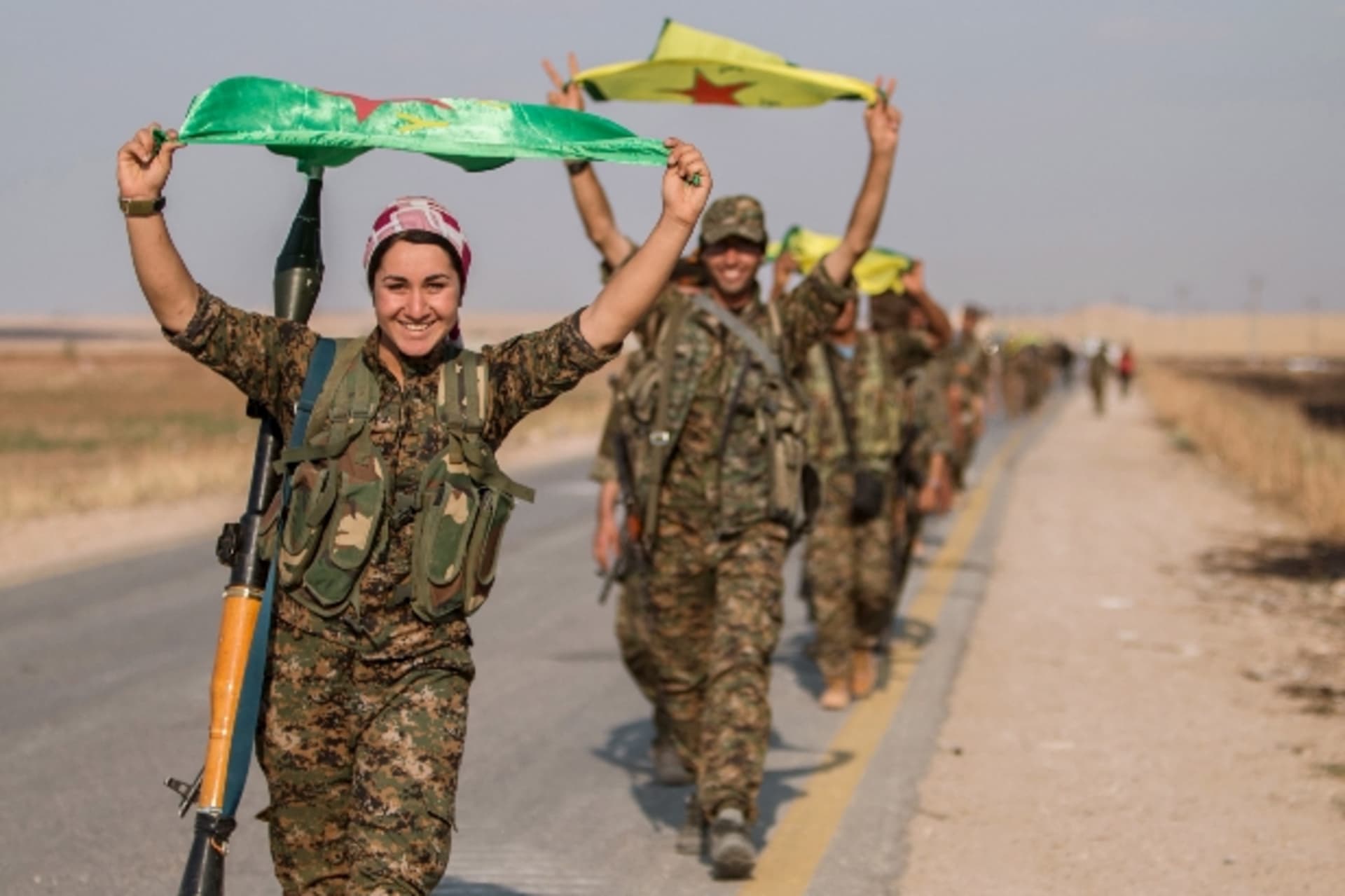 <p>Kurdish fighters gesture while carrying their parties’ flags in Tel Abyad of Raqqa governorate after they said they took control of the area June 15, 2015 </p>