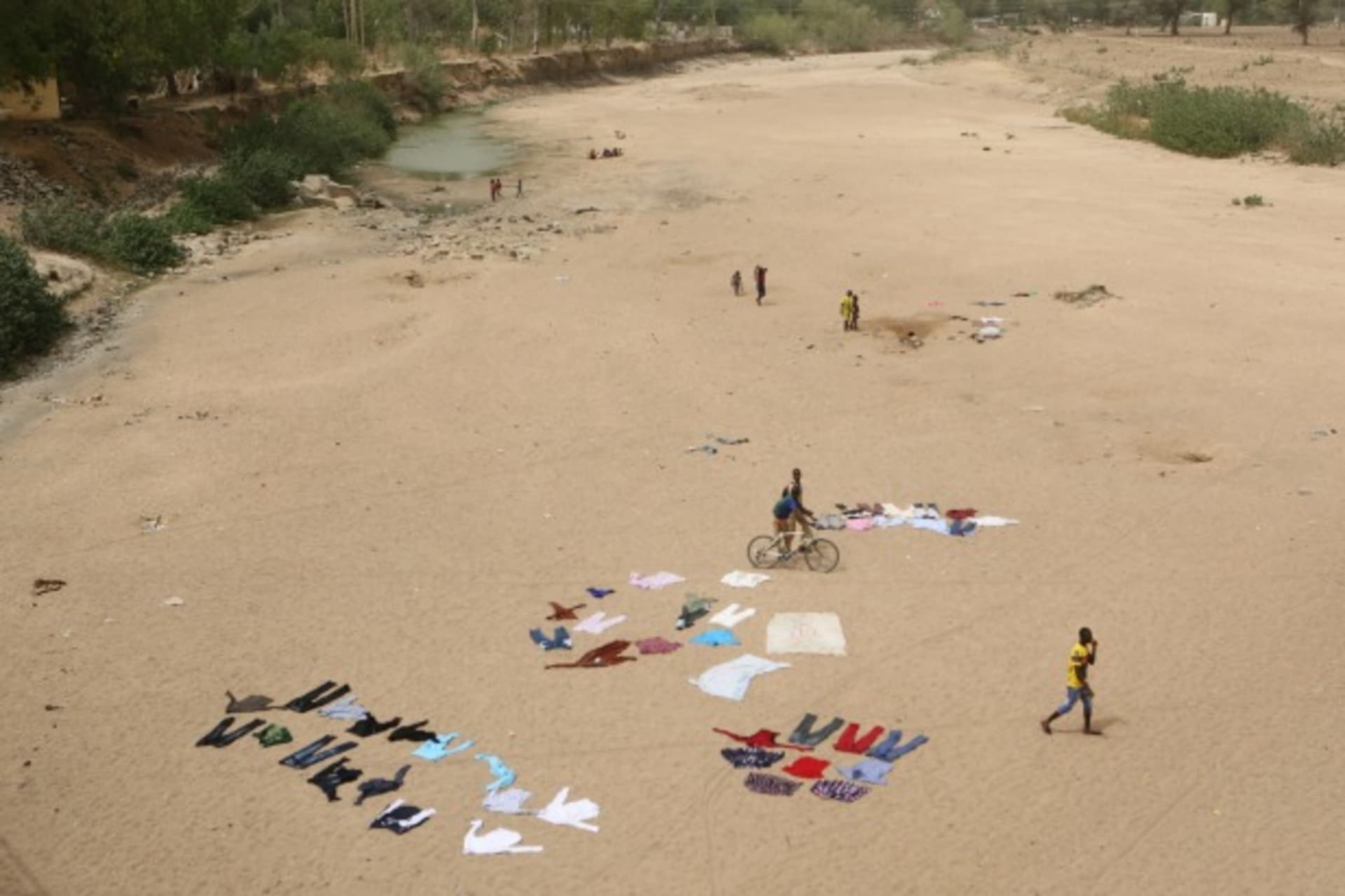<p>People wash clothes in a dry riverbed in Maroua, Cameroon, March 17, 2016. (Reuters/Joe Penney)</p>
