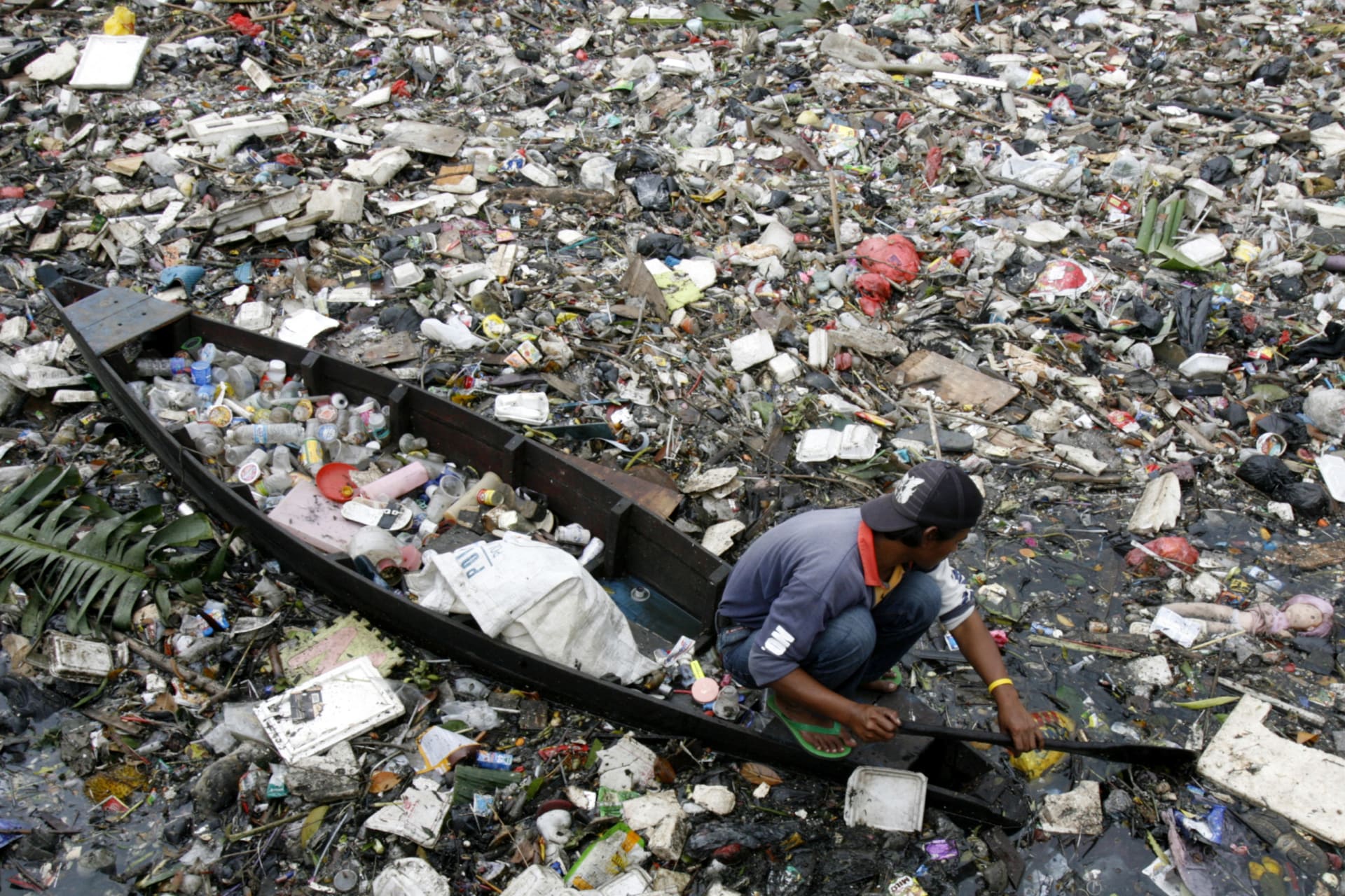 <p>A man sifts through a polluted river in Jakarta, Indonesia. </p>

